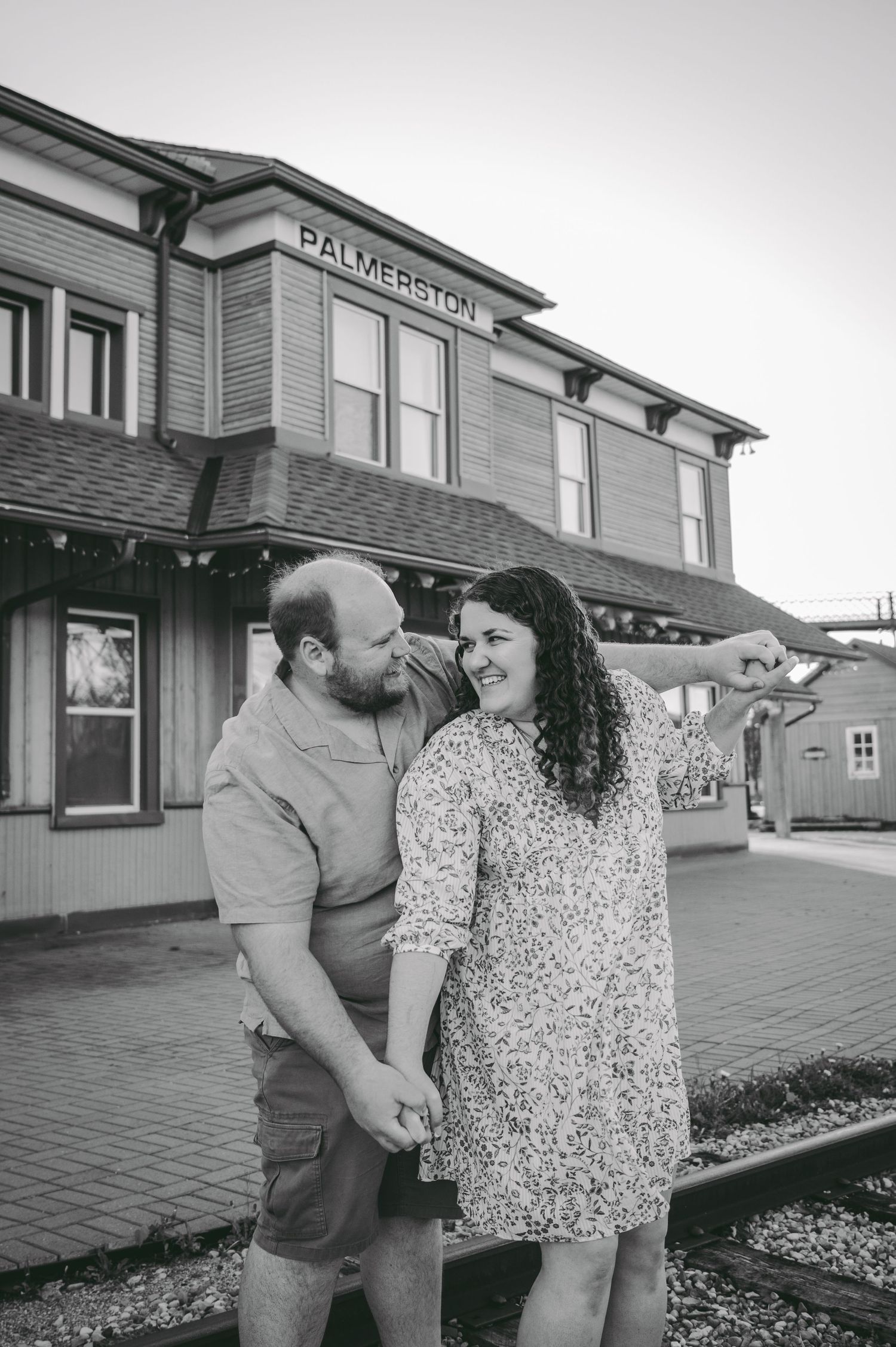A couple shares a candid moment outside the historic Palmerston Train Station.