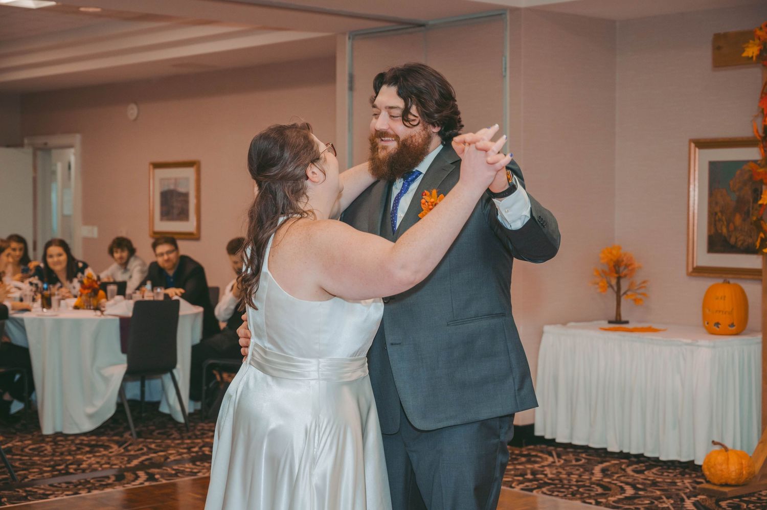 Wedding reception dance floor with decorative pumpkins and autumn decor.
