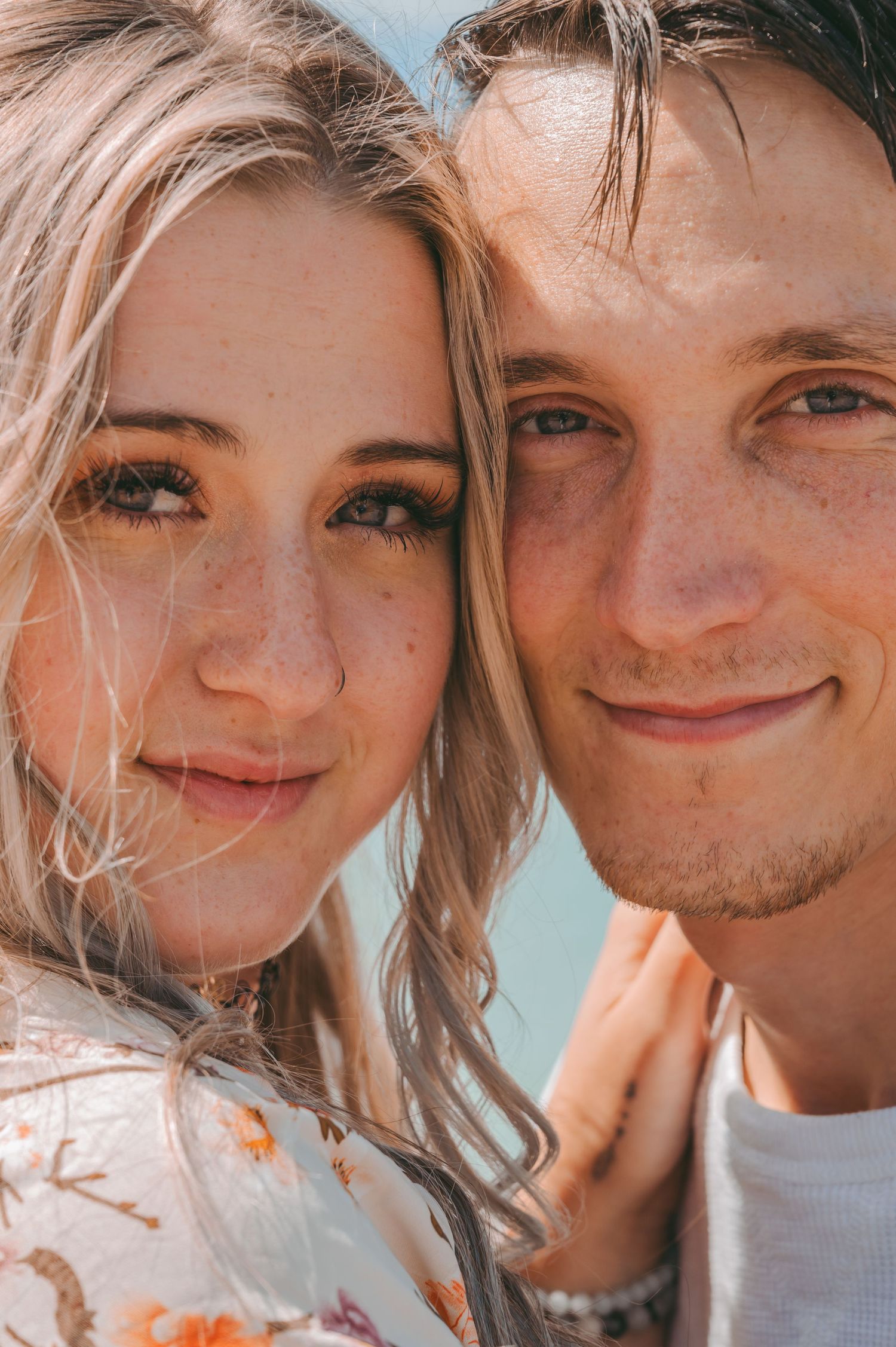 Sun-kissed close up portrait against blue ocean background on bright summer day.