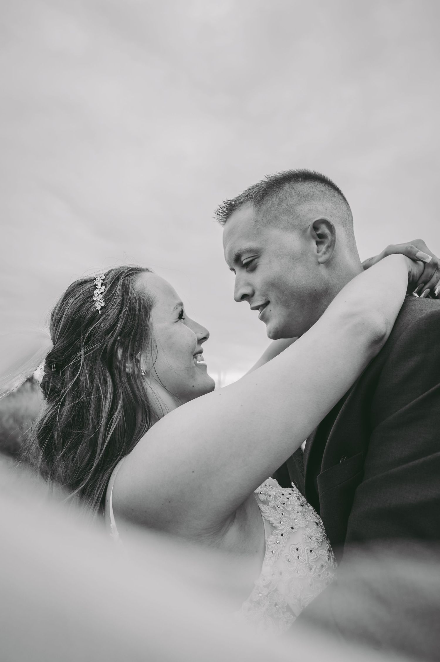 A black and white romantic portrait of a couple sharing an intimate moment during a wedding photoshoot.