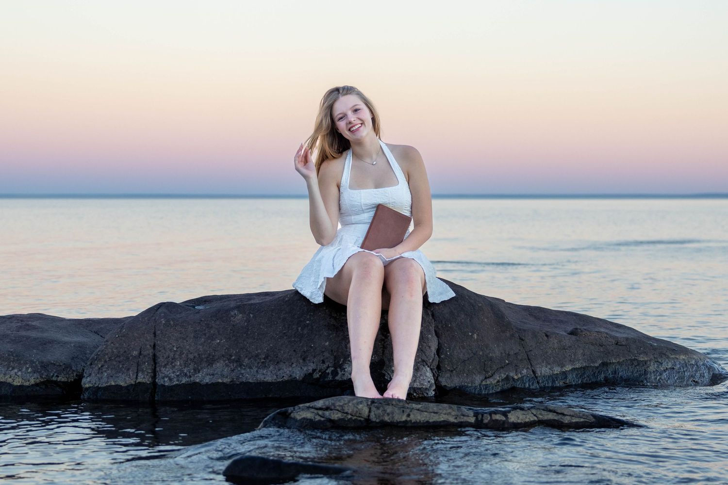 A series of photos shows someone sitting on coastal rocks at sunset by the ocean's edge.