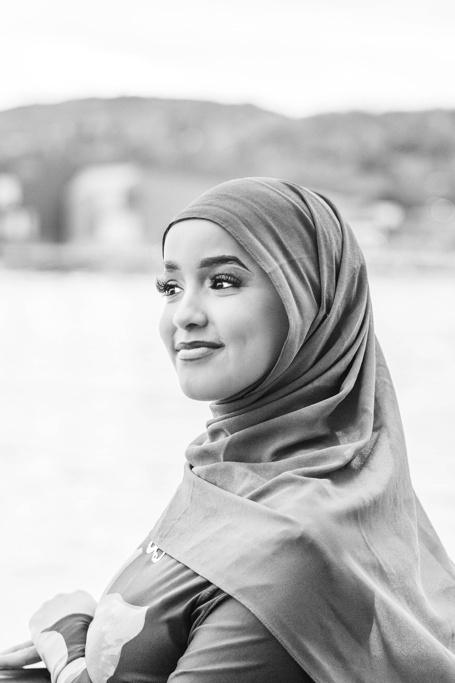 Black and white portrait series showing a person in hijab smiling and looking to the side in multiple poses.