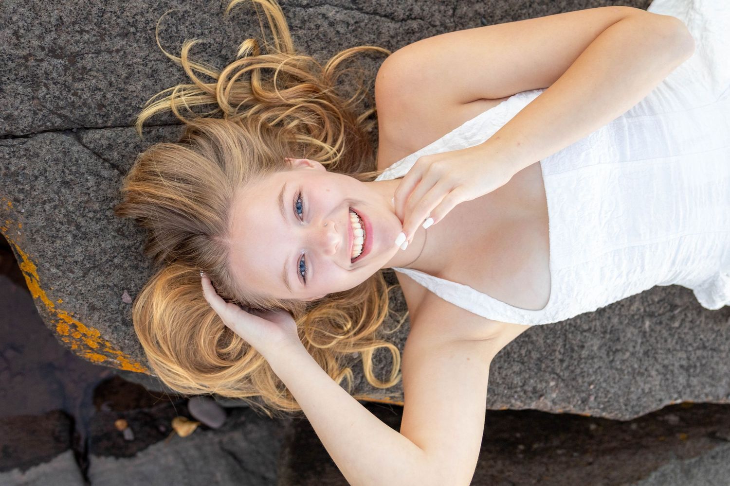 Creative portrait series featuring artistic poses on a textured gray stone surface with dramatic angles.