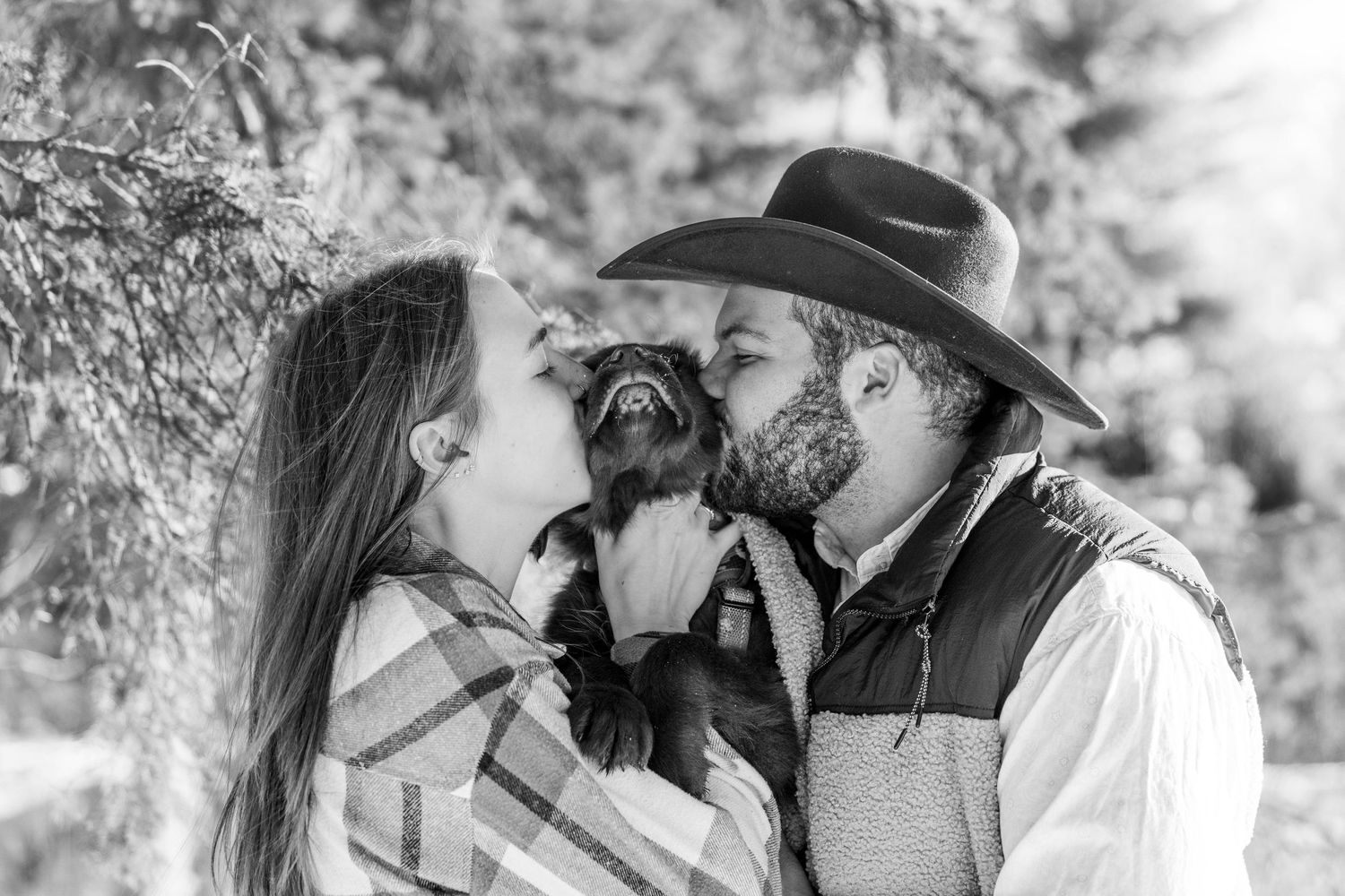 A romantic black and white photo series of a couple sharing intimate moments in a natural outdoor setting.