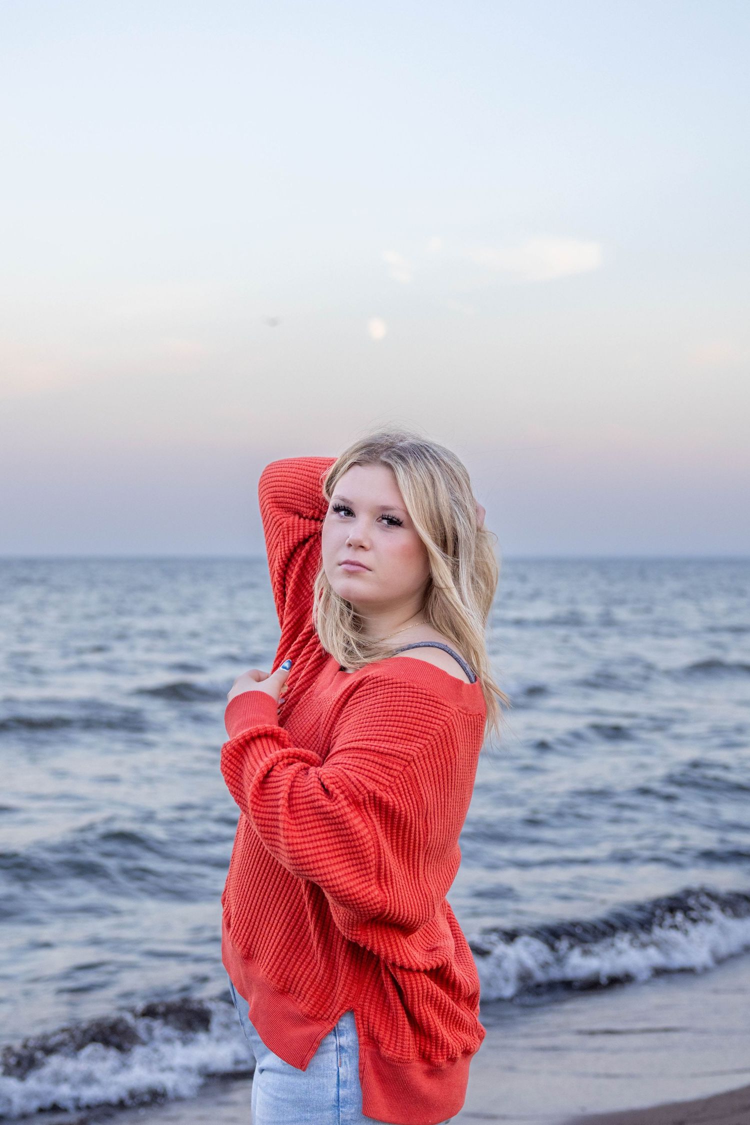 A sequence of beach portraits featuring someone in a bright red sweater against an ocean backdrop at dusk.