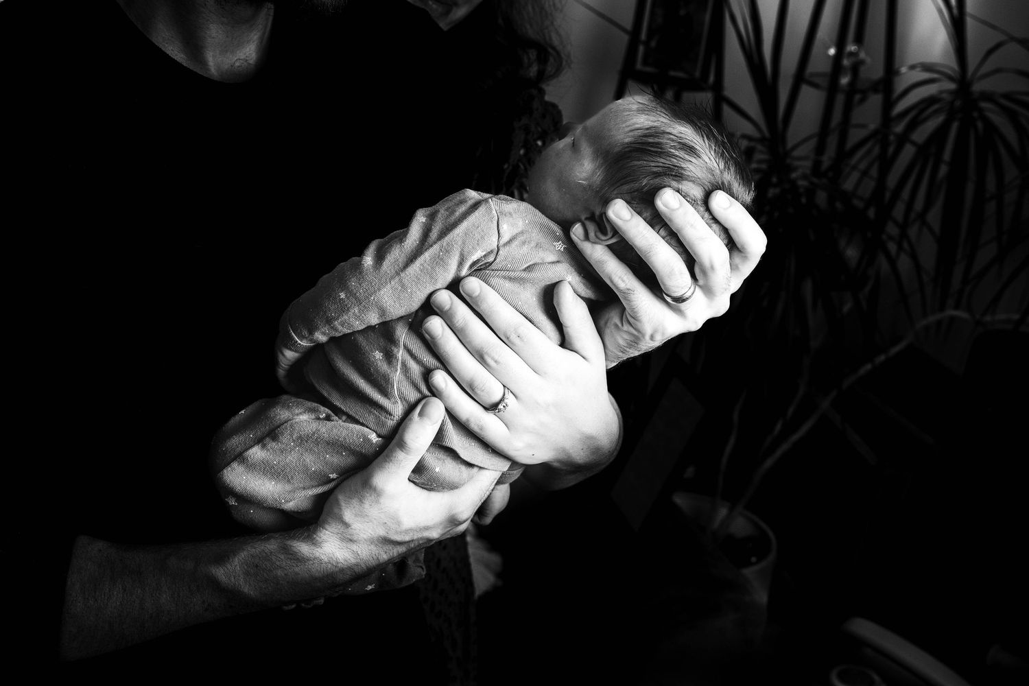 Black and white photo series showing hands in various positions holding and manipulating objects in dramatic lighting.
