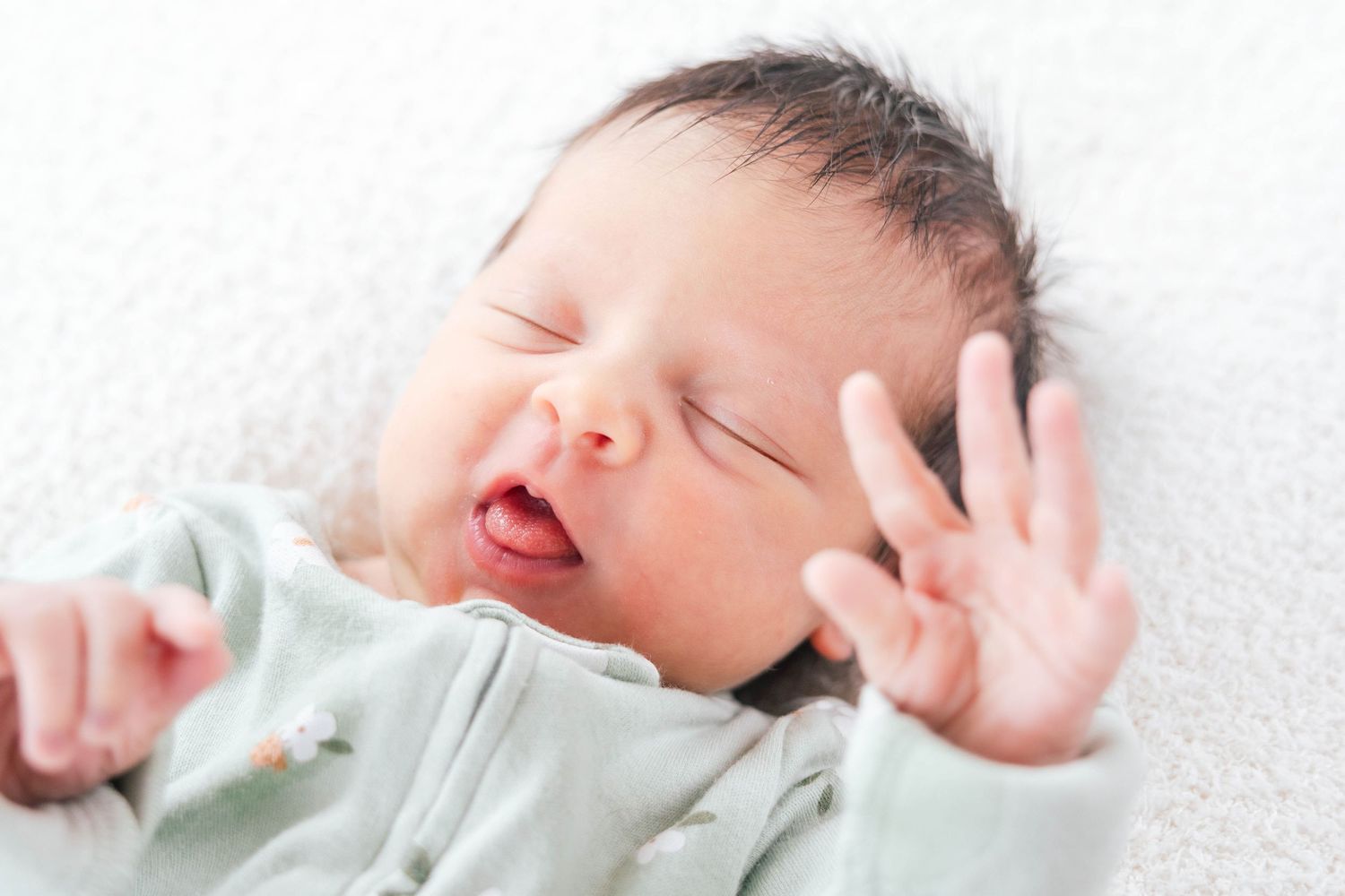 A collage of sleeping newborn babies in white swaddling blankets on soft textured backgrounds.