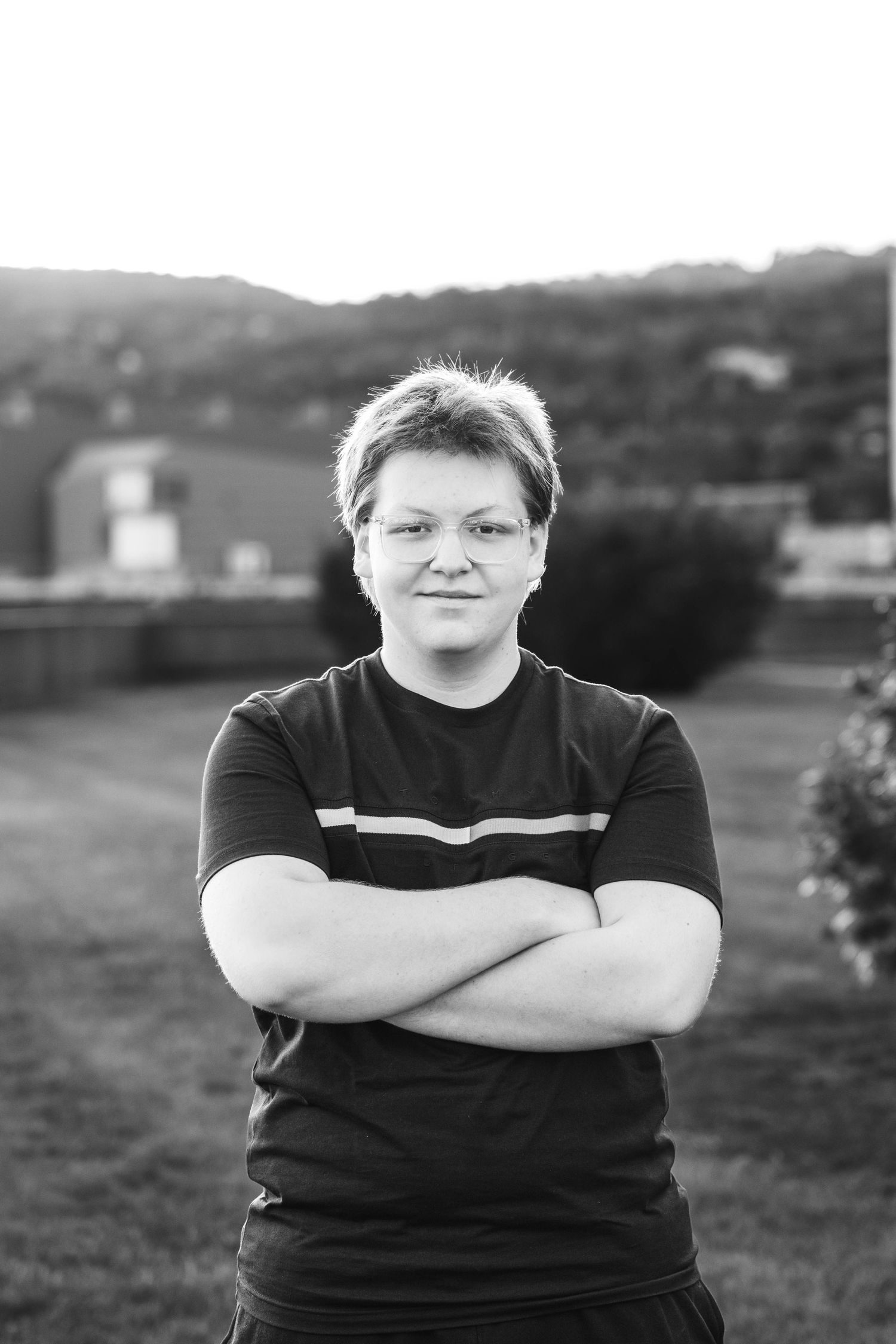 A series of black and white portraits showing someone wearing a black t-shirt in an outdoor setting.