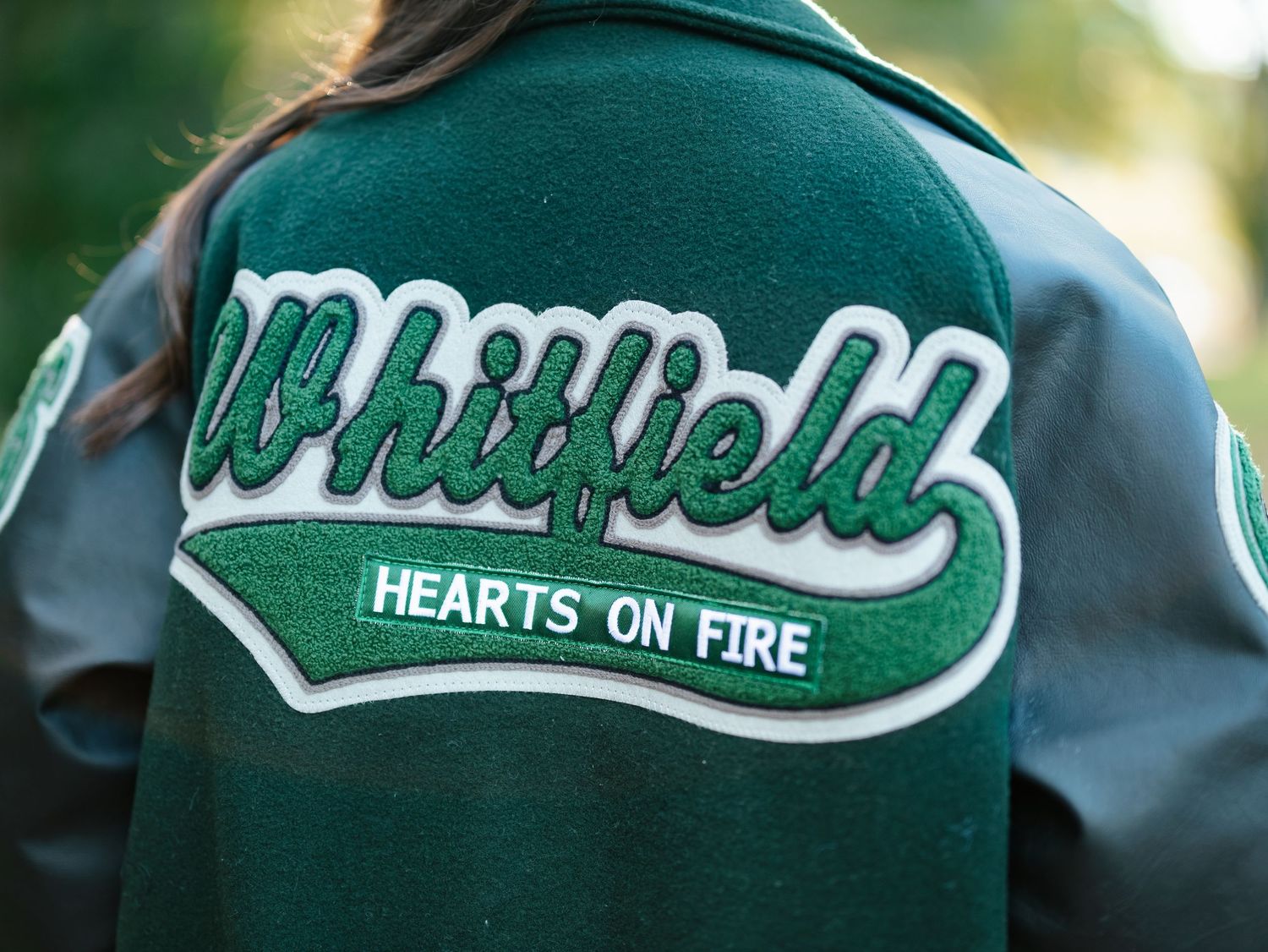 Green Whitfield varsity letterman jacket with Hearts on Fire patch on the back.
