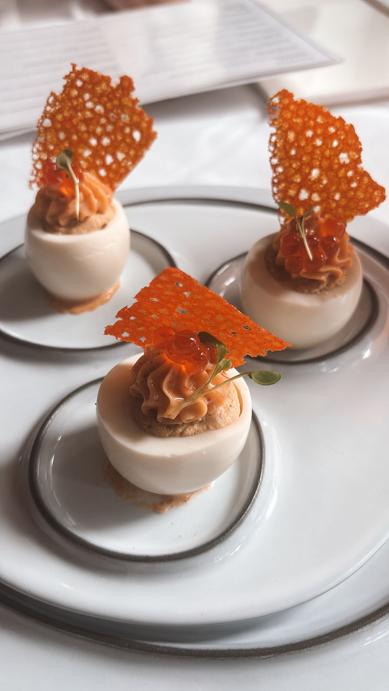 Elegant plated appetizer with crispy garnish served on a white dish at a fine dining restaurant