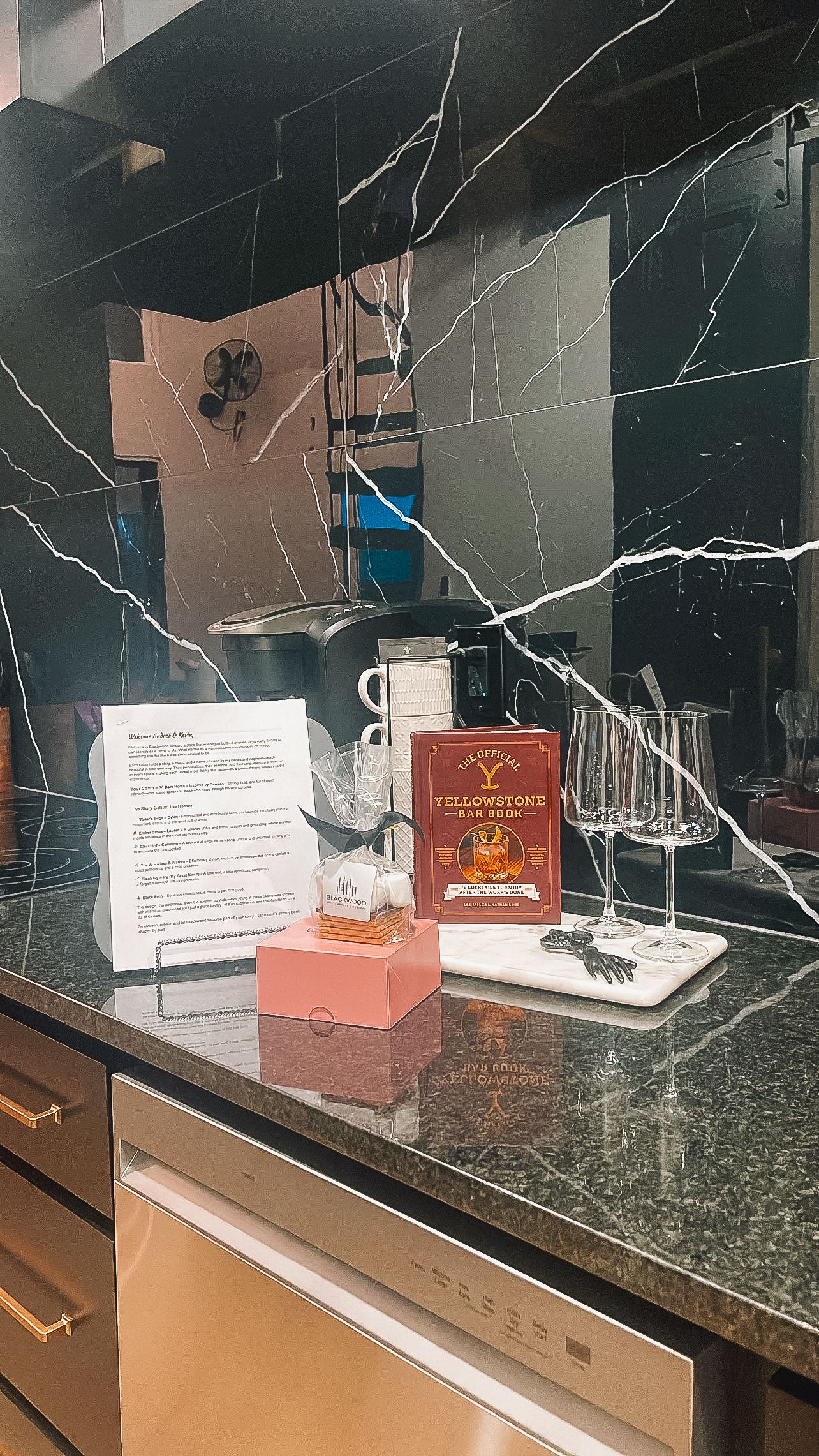 Stylish bar setup with cocktail ingredients and recipe cards on a granite countertop