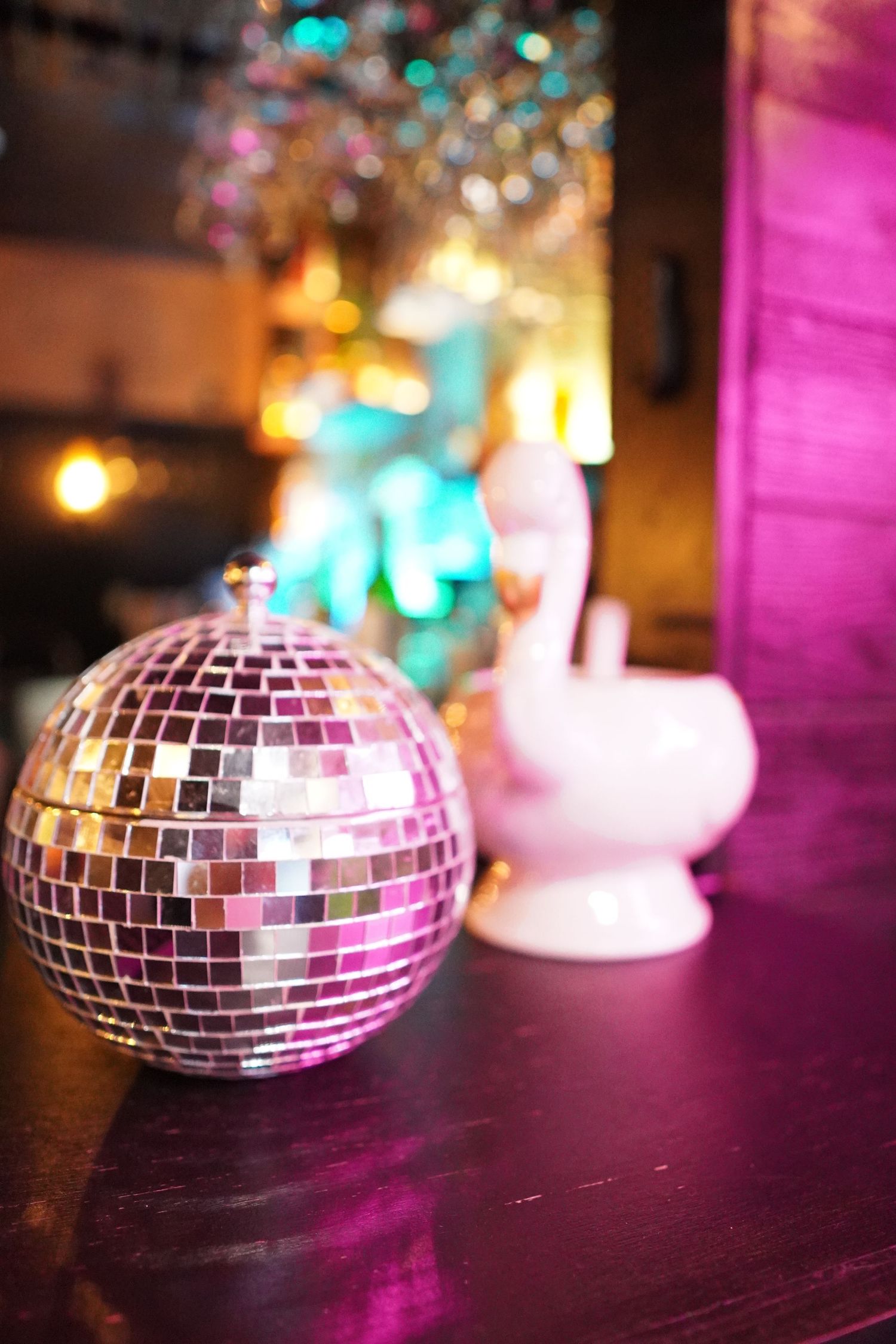 Disco ball and candles on a vibrant table setup with moody lighting