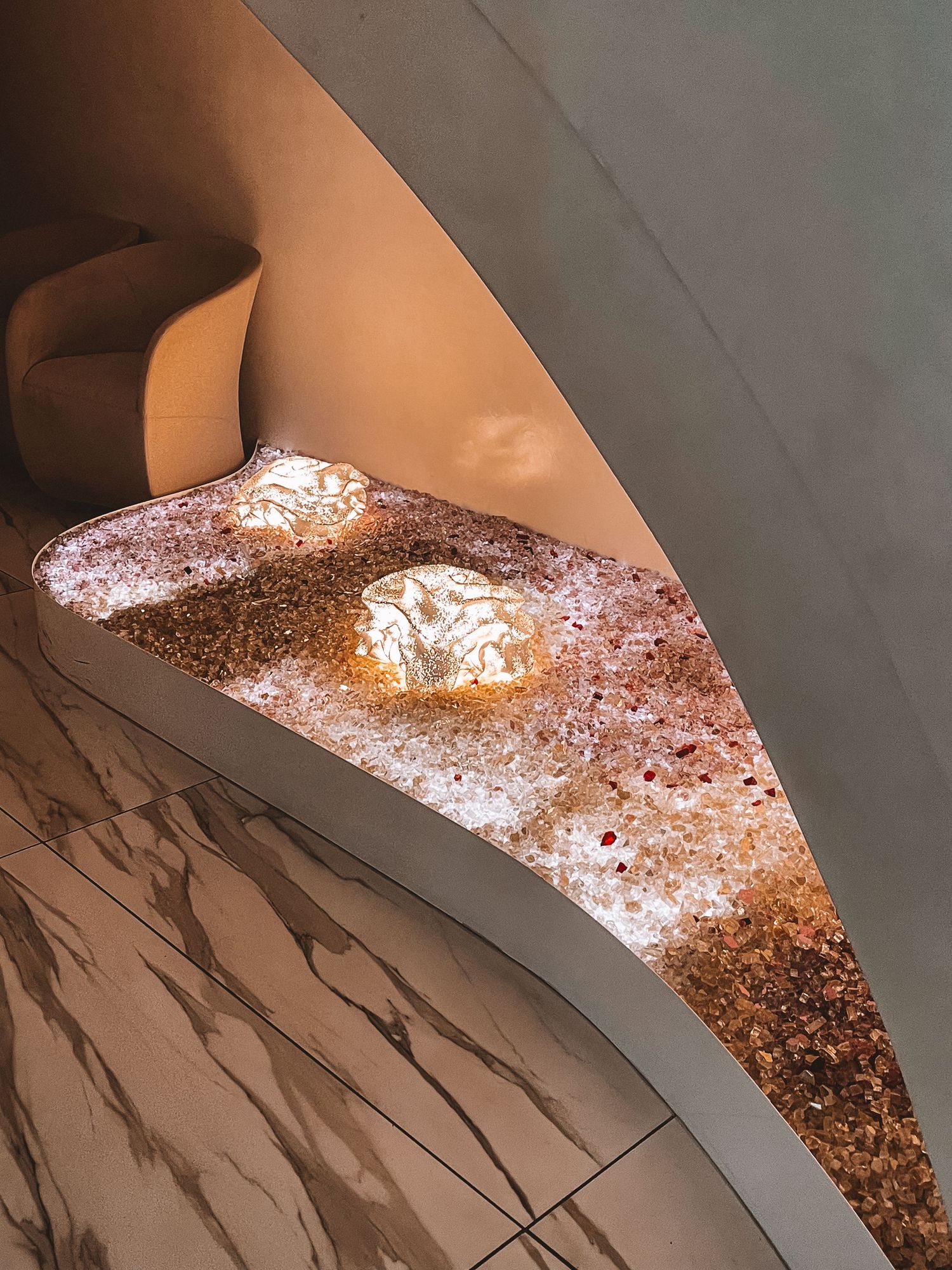 Golden staircase detail with ambient lighting and glimmering sequin-style texture along the edge
