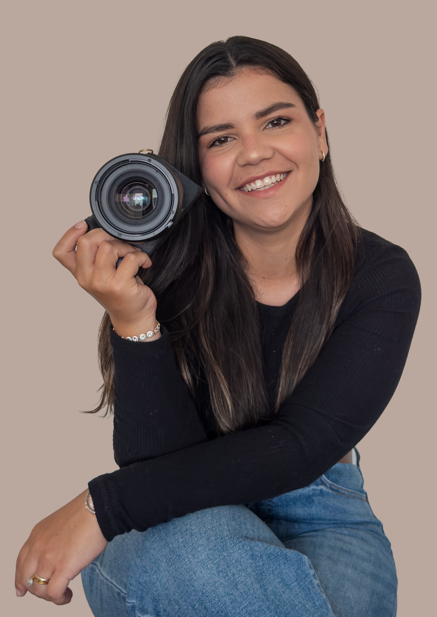 Portrait of Colombian photographer Laura Mahl smiling while holding her camera, based in New York City and specializing wedding and portrait