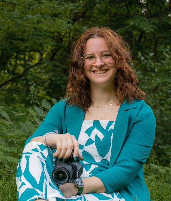 A young but experienced photographer holding onto a camera