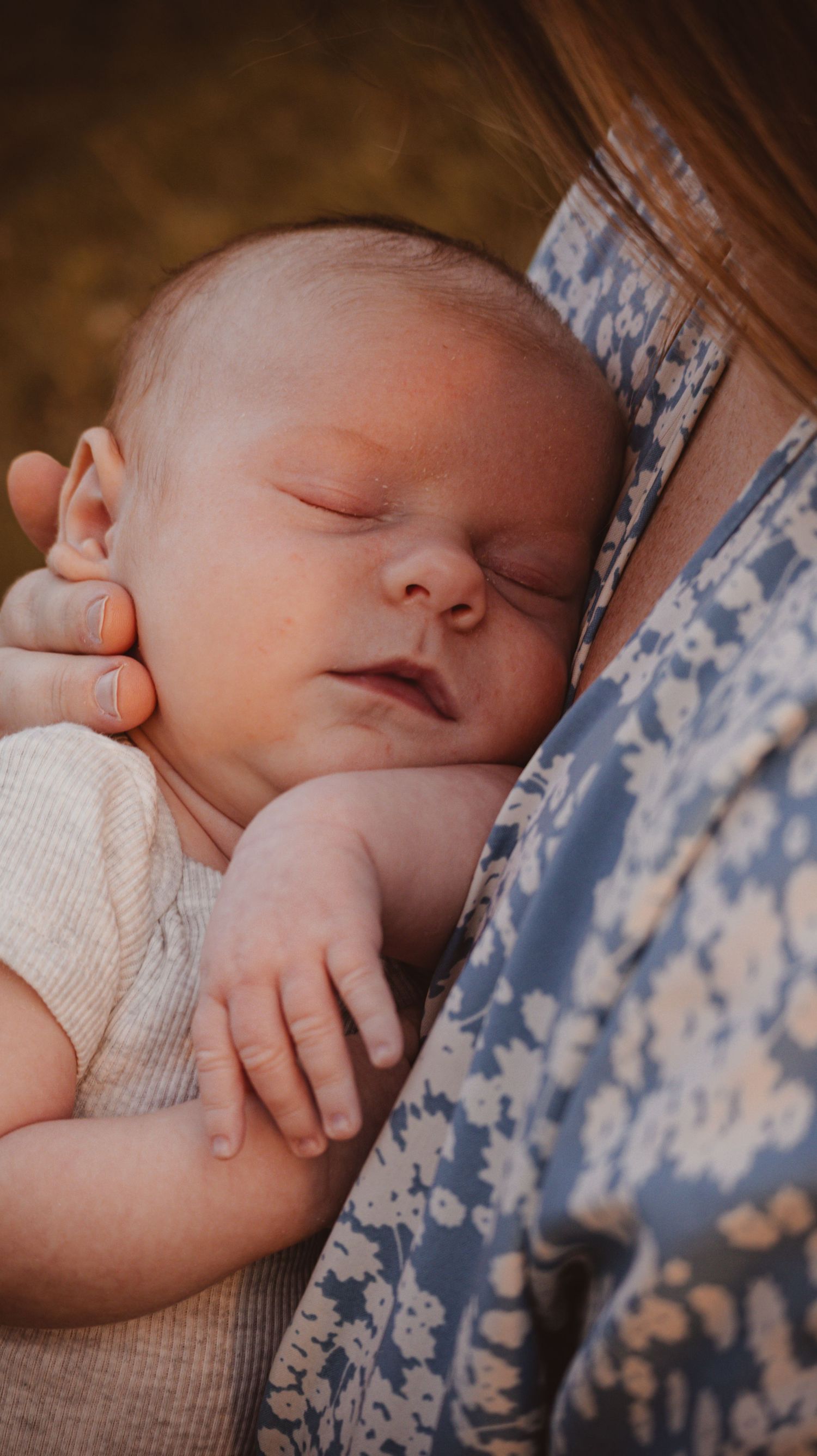 A cozy and timeless photo of a mom holding her sleeping newborn baby