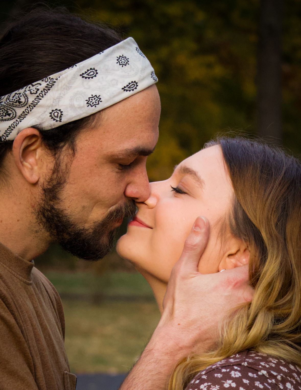 A happily engaged couple's photo of them kissing and smiling