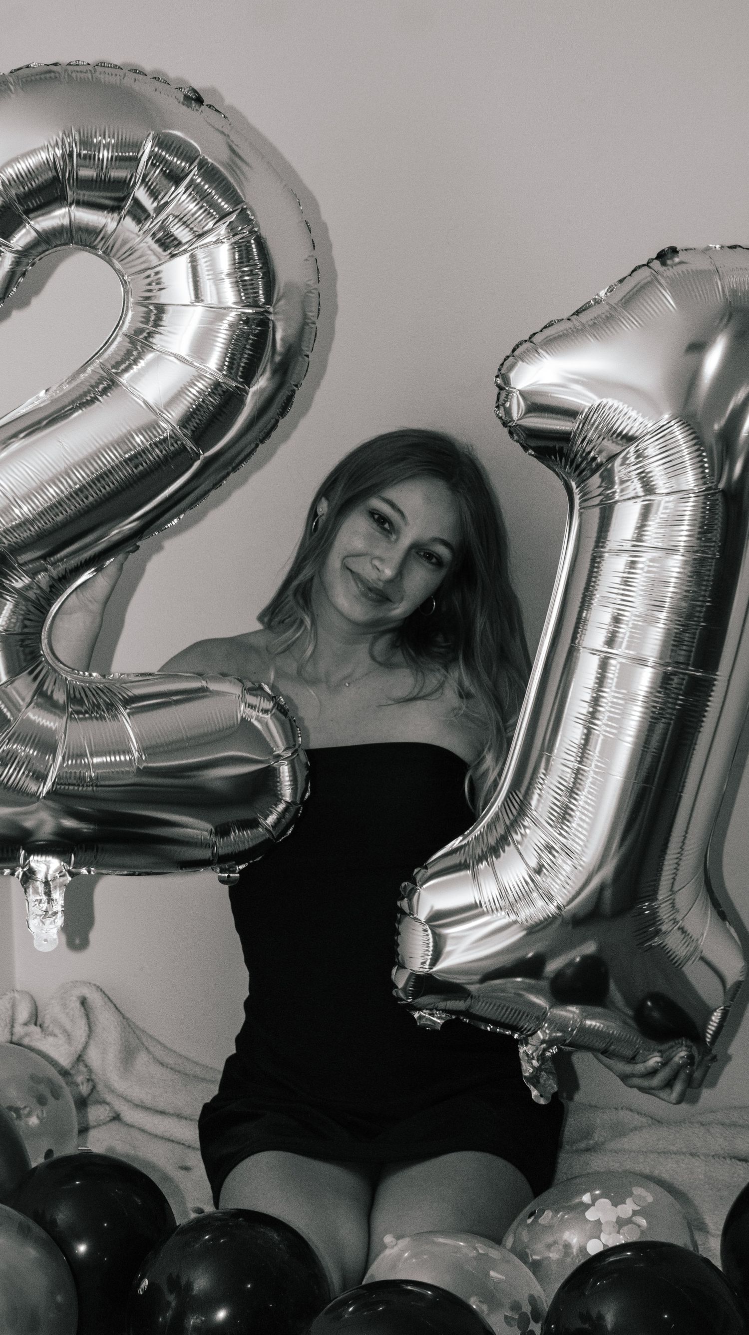 Woman celebrating her twenty-first birthday with some fun numbered balloons