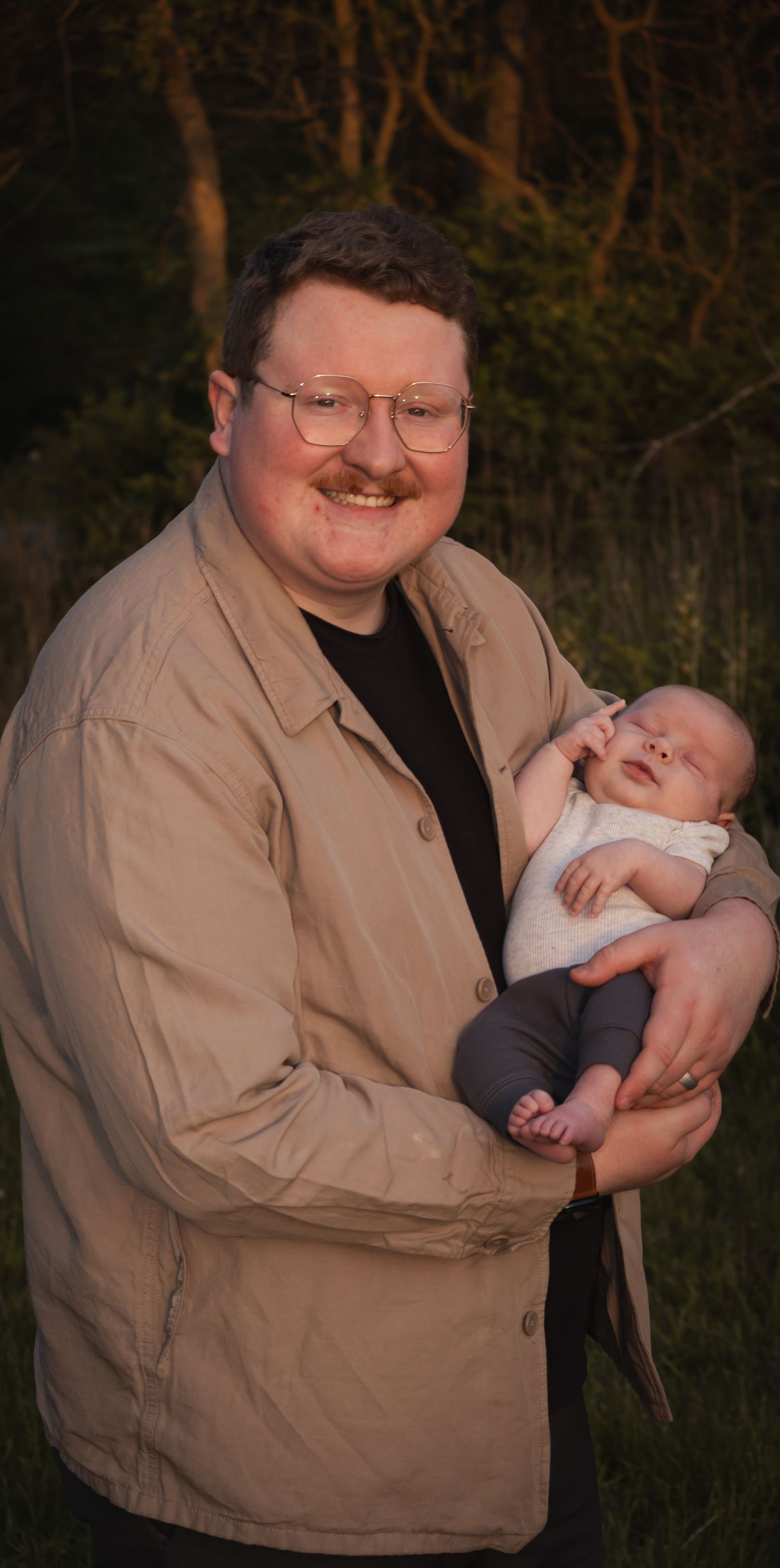 A proud dad smiles as he holds his newborn baby!