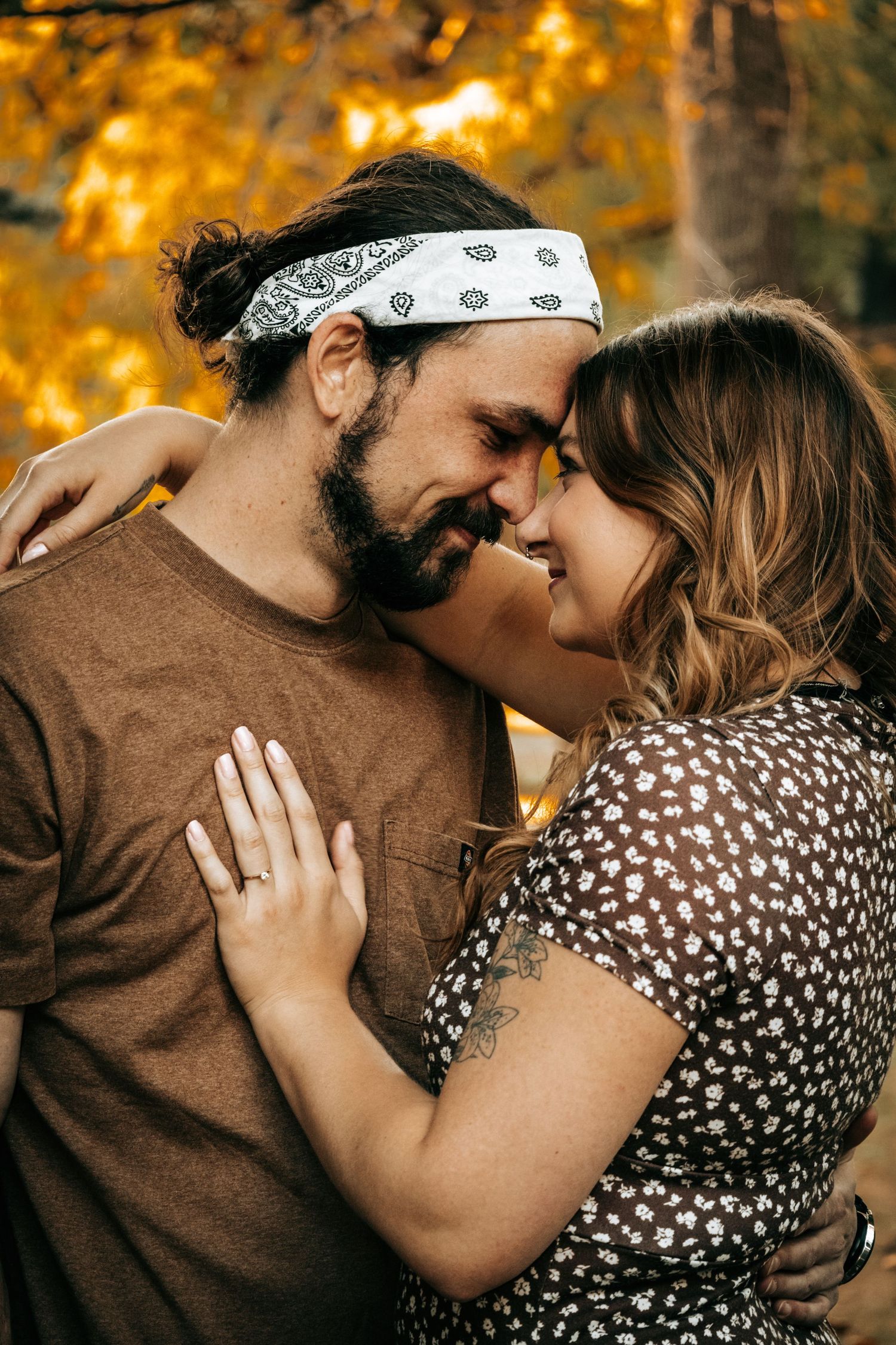 A happily engaged couple, touching foreheads and smiling at each other
