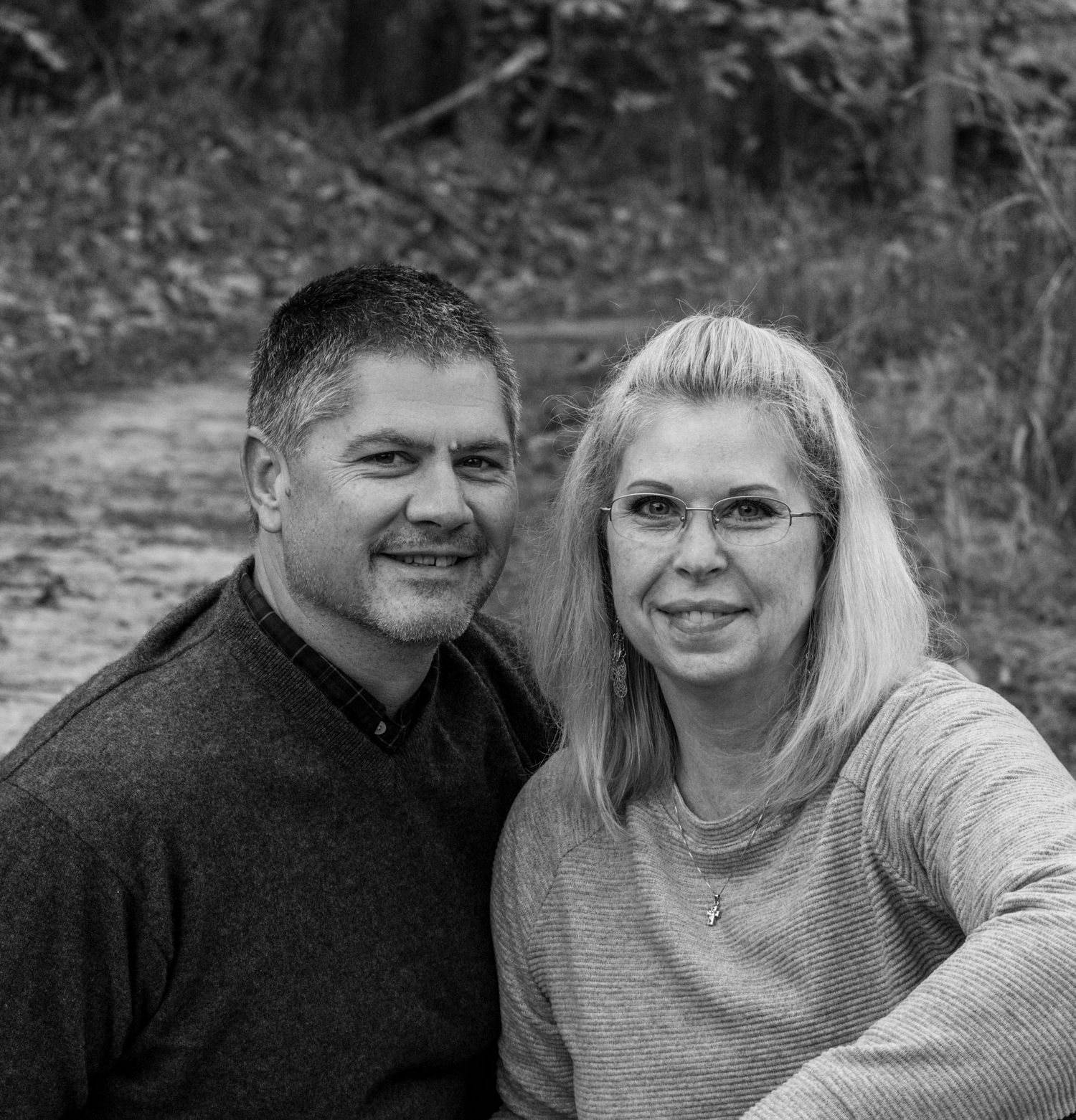 A black and white photo of a happily married couple sitting on the ground