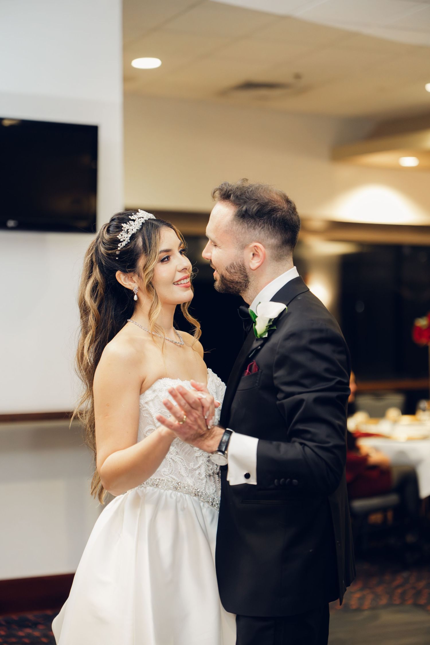 Bride and groom sharing first dance at wedding reception venue.