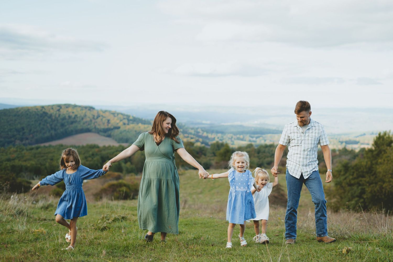 Family holding hands and walking along the Saddle Overlook on The Blue Ridge Parkway