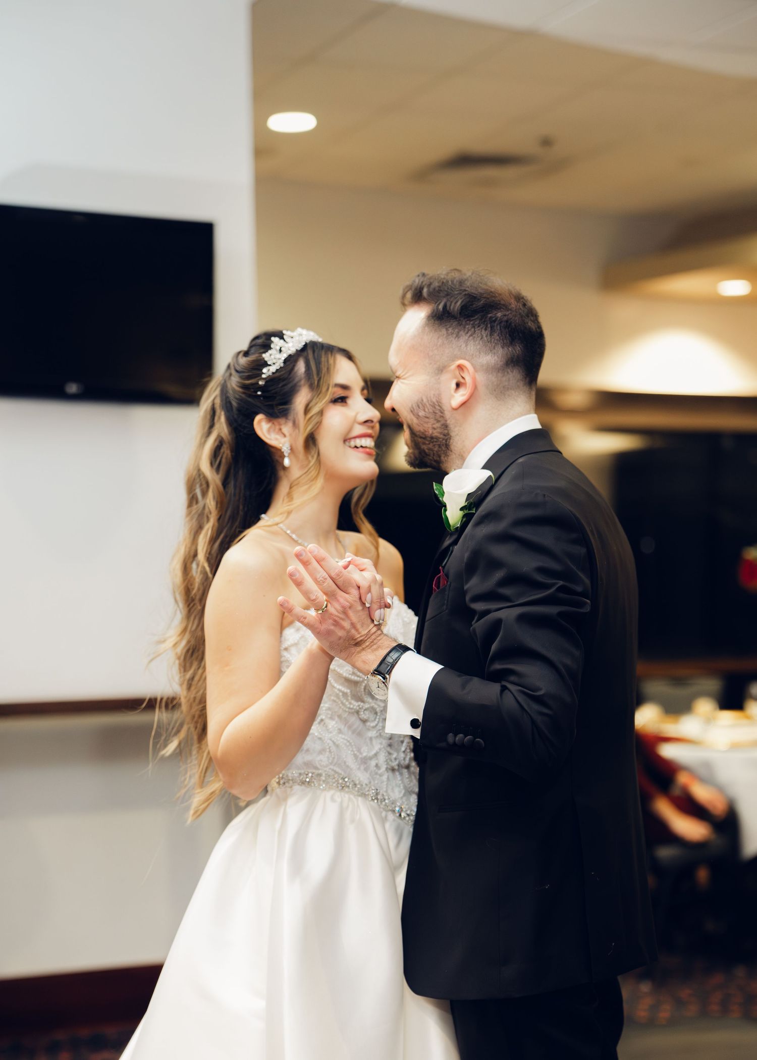 Smiling bride and groom share intimate first dance moment at wedding reception.