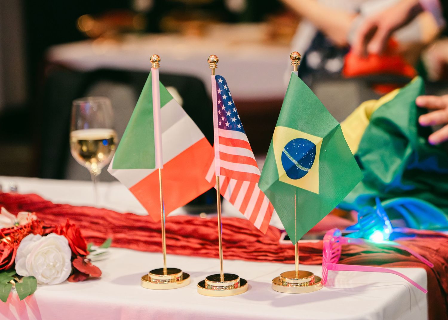 Italian, American, and Brazilian flags displayed as centerpiece decorations at a wedding reception.