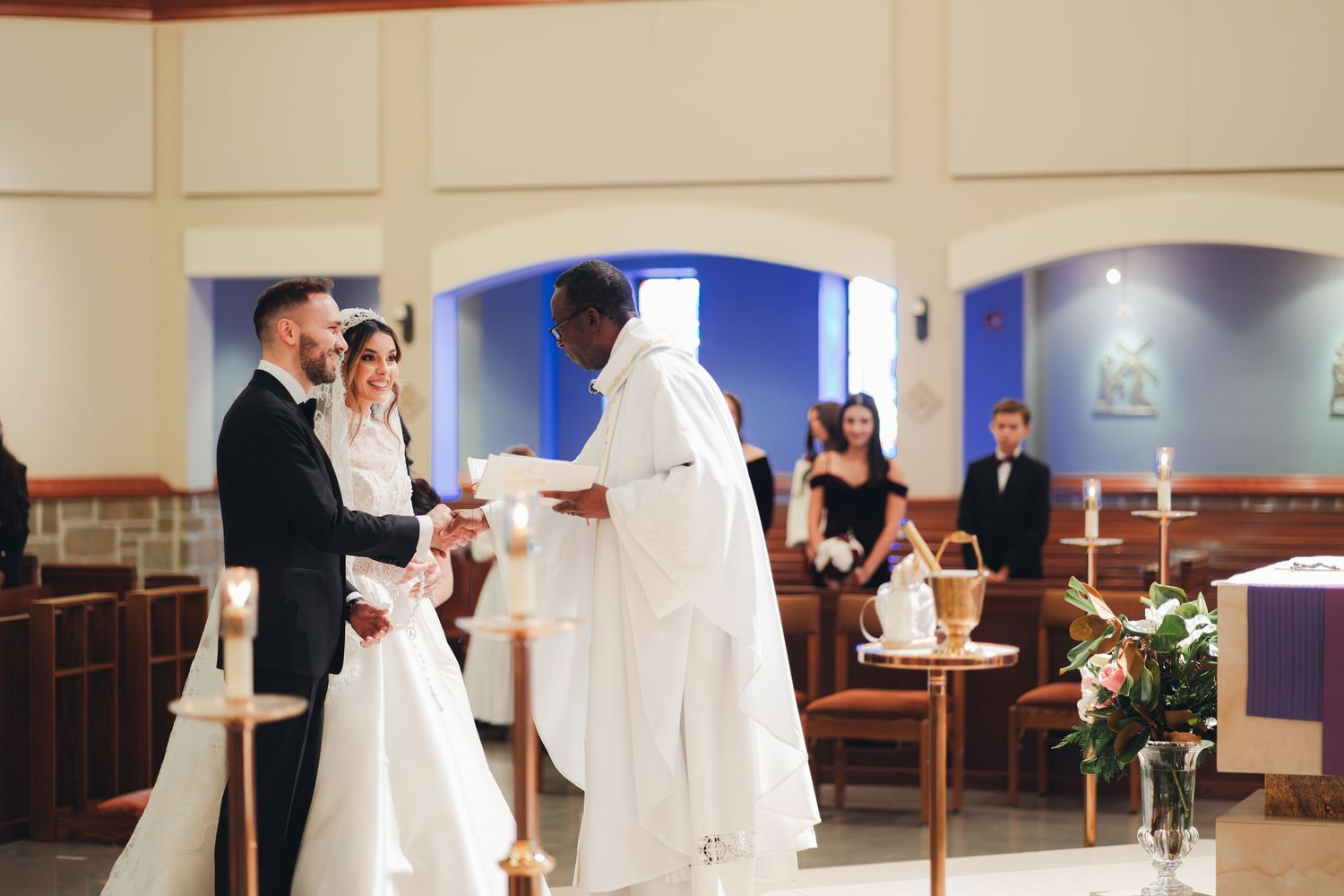 Bride and groom exchanging vows with priest during traditional church wedding ceremony.
