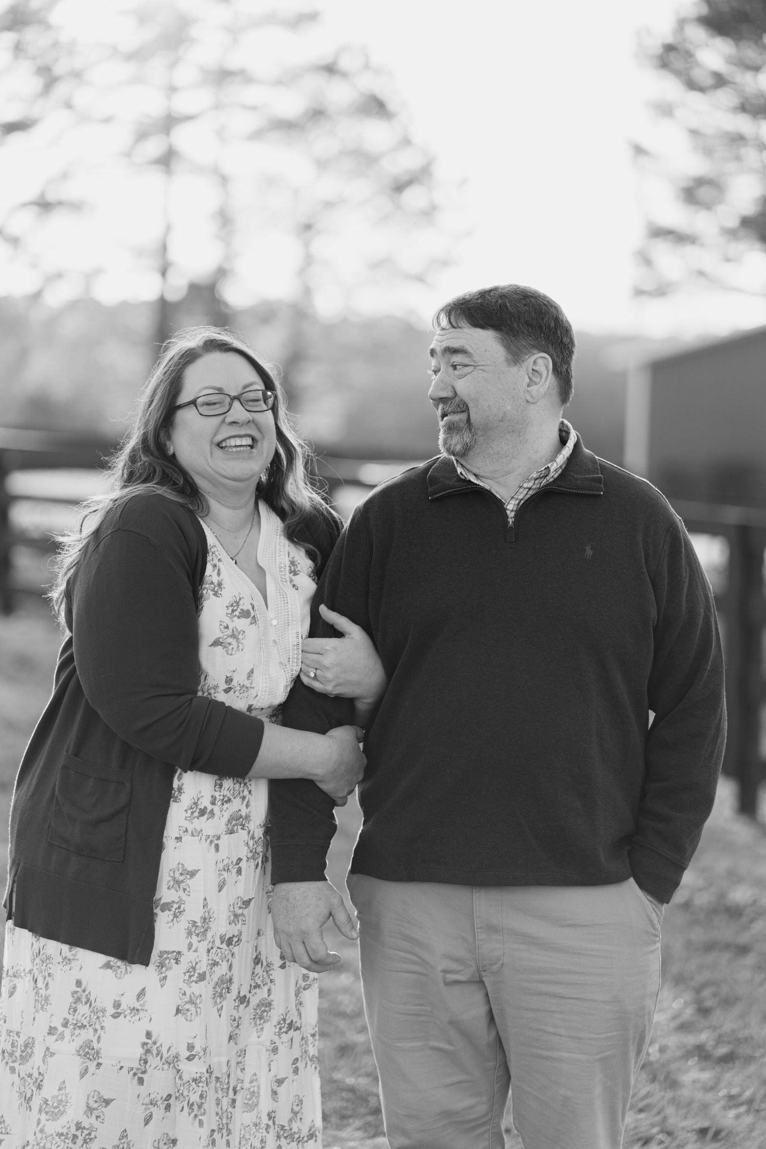 Happy couple laughing together outdoors in black and white photo.