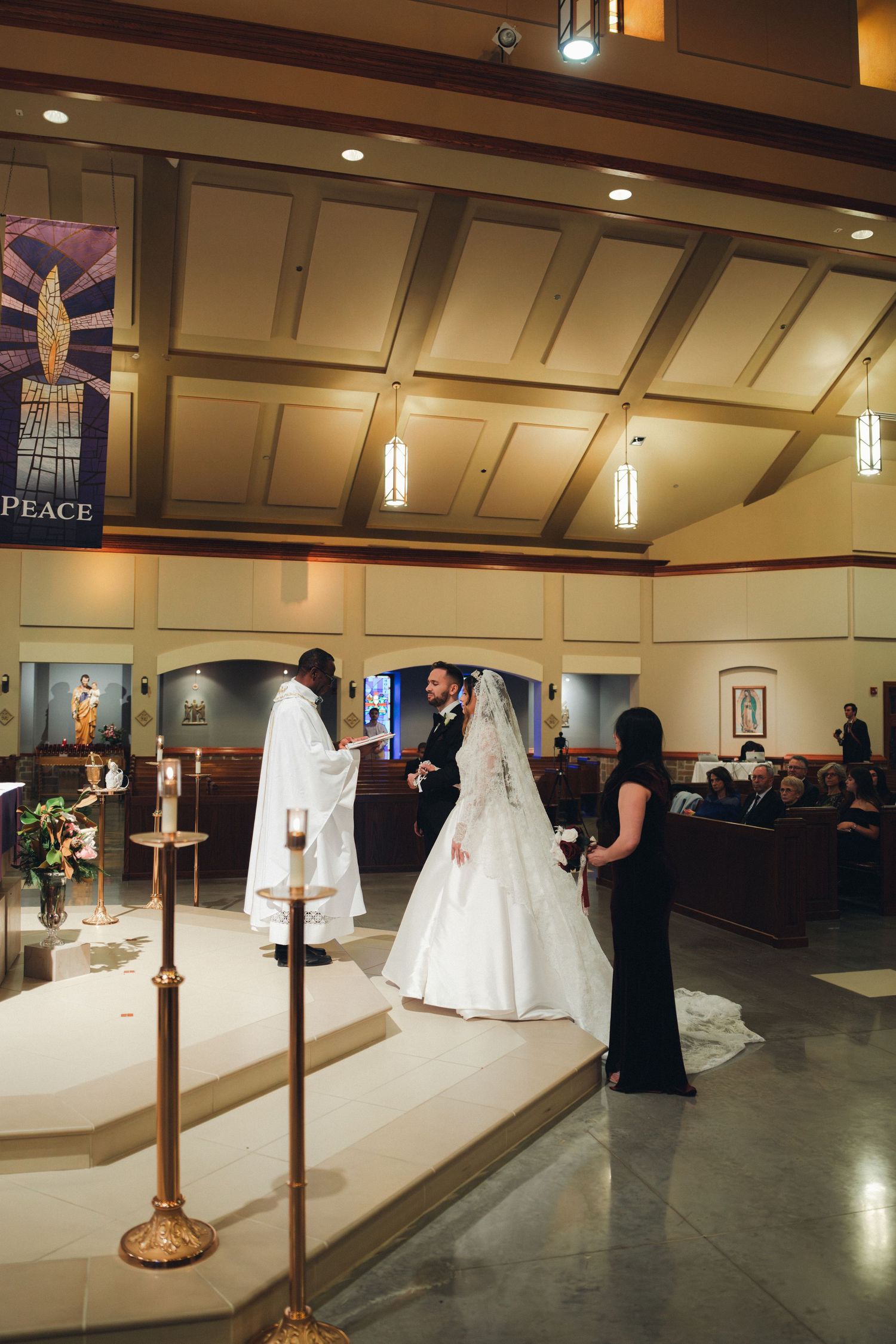 Bride and groom exchange vows at church altar with priest during wedding ceremony.