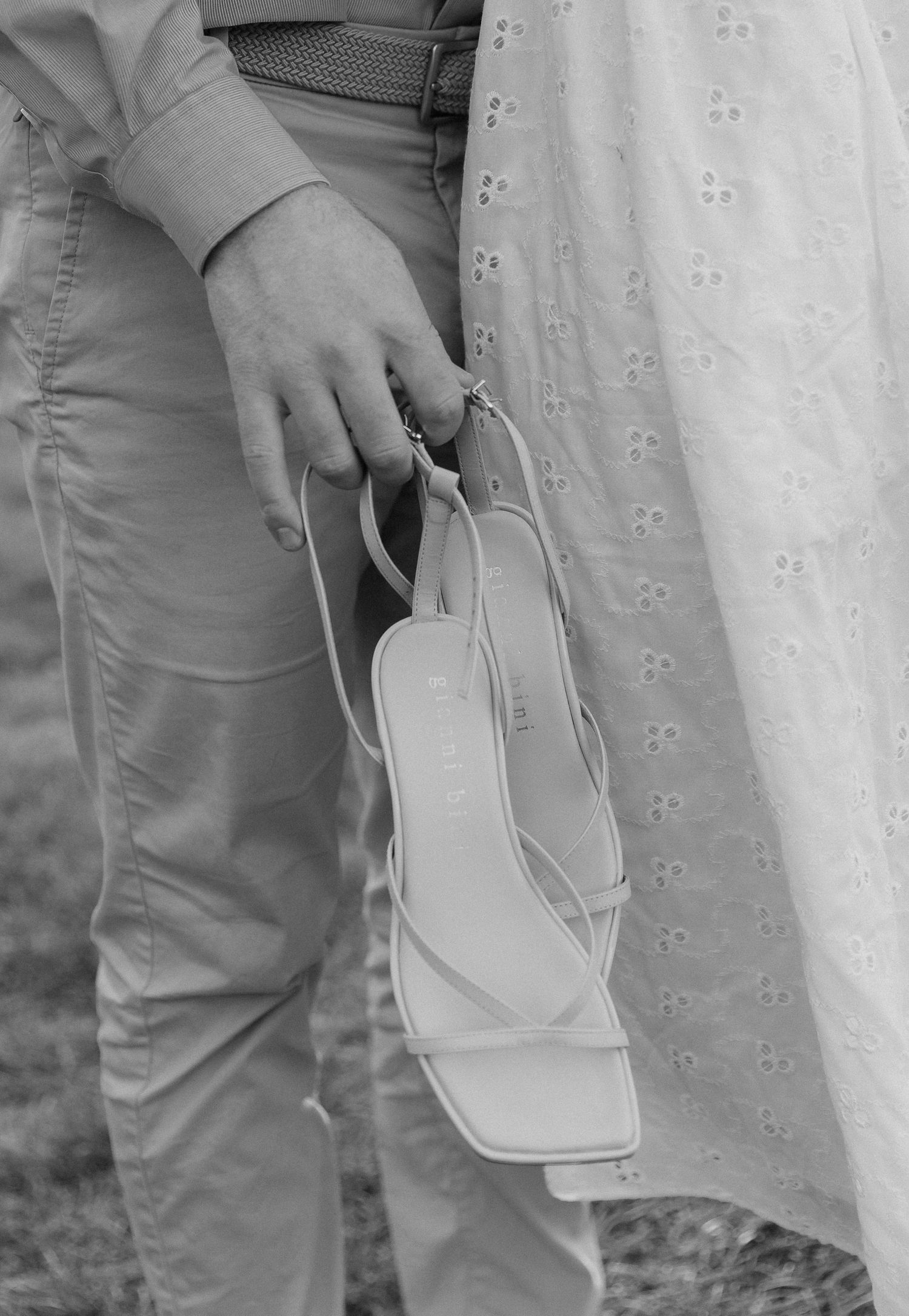 Five cropped black and white closeup images showing a white handbag held against a dress and pants.