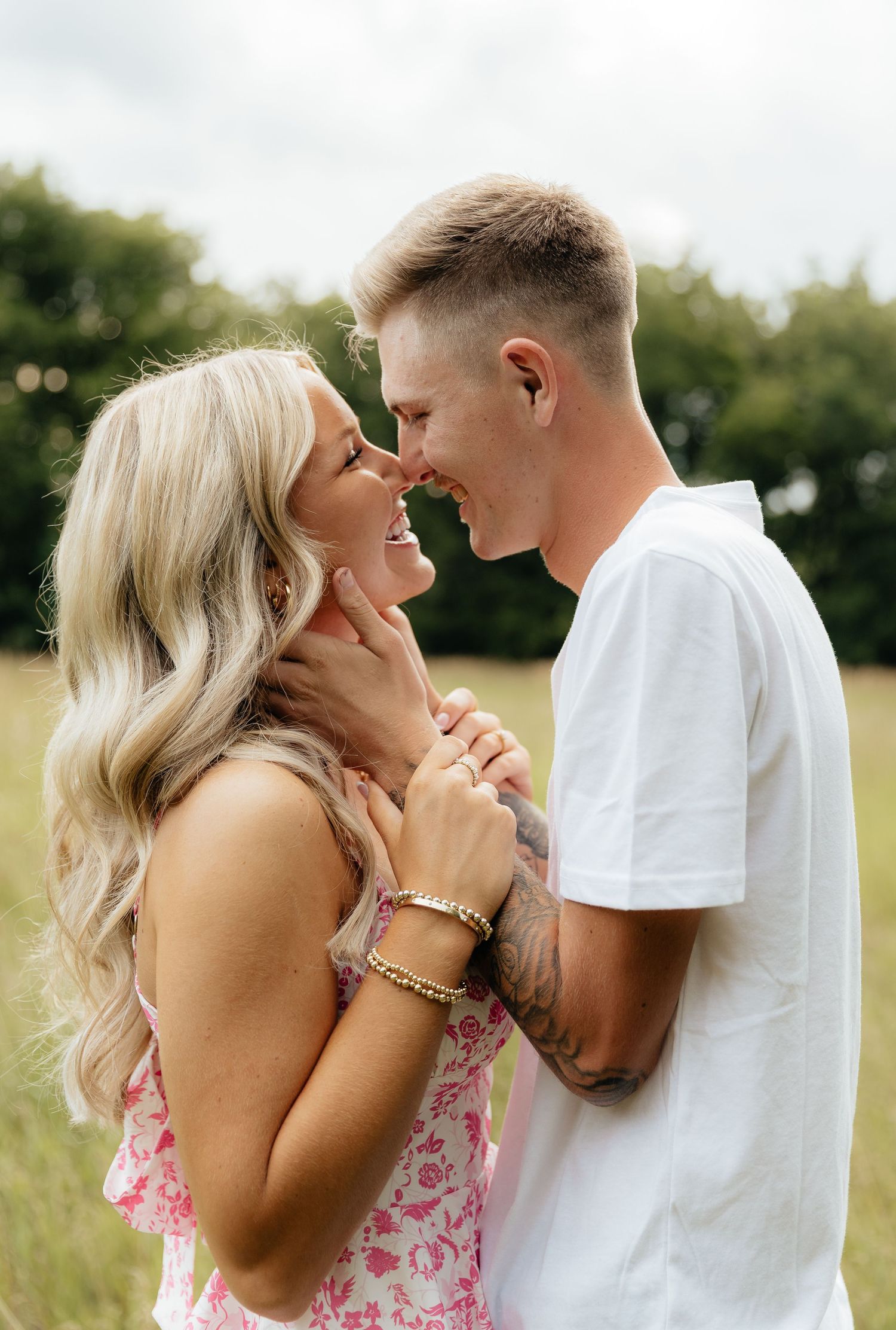 Intimate moment between couple laughing together in summer field.