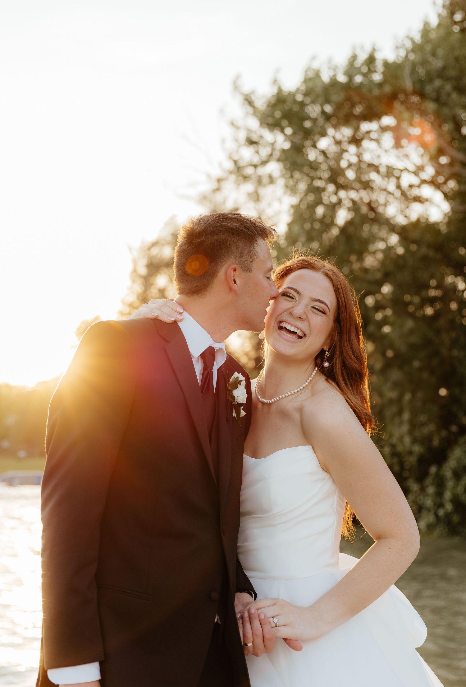 Sunset wedding portrait with joyful couple against natural backdrop.