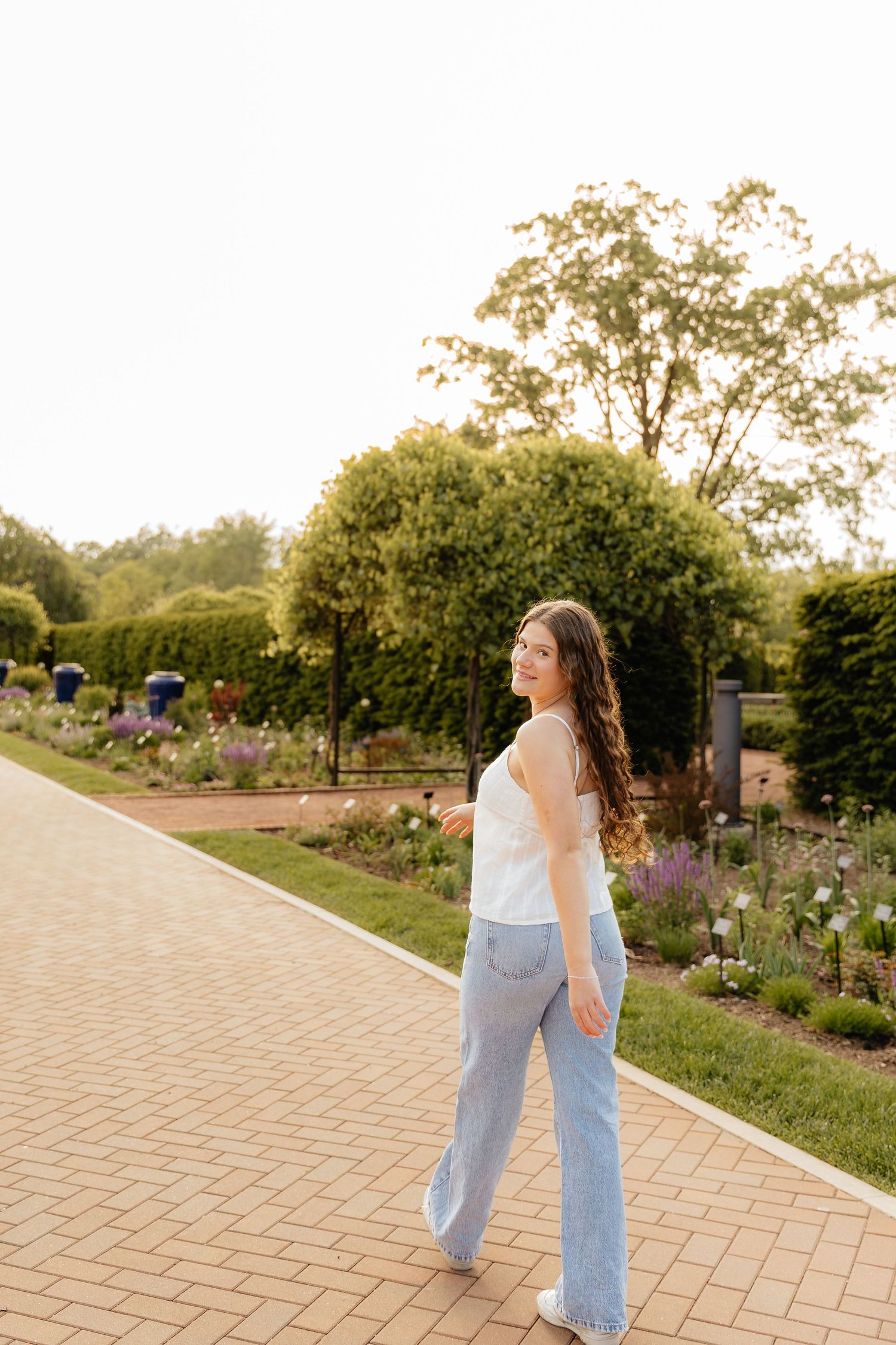 A series of casual outdoor portraits along a brick pathway in a garden setting.