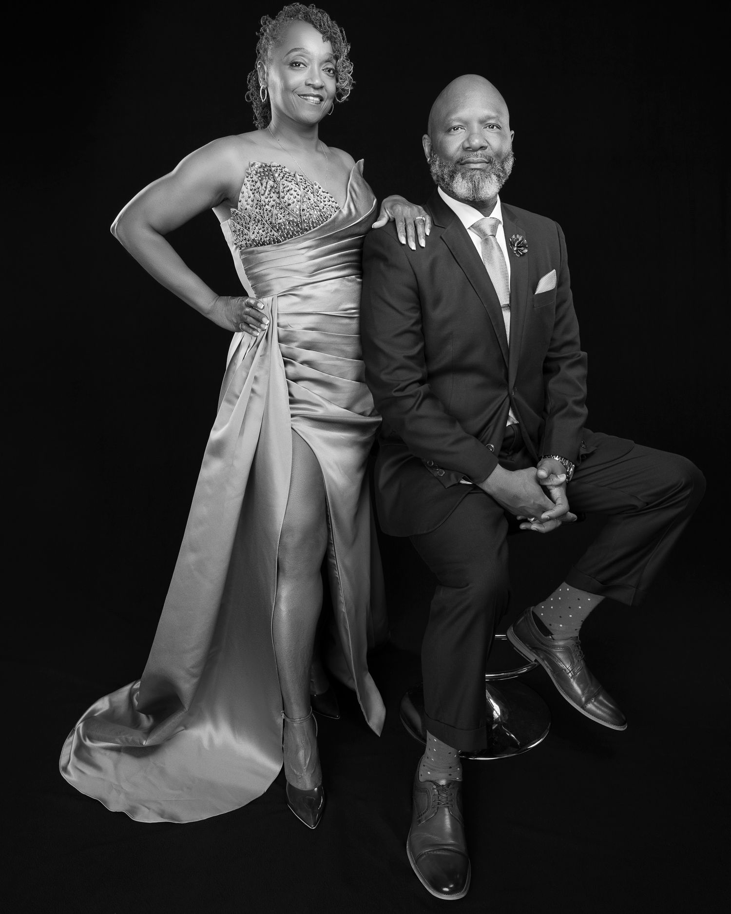 Black and white formal portrait showcasing elegant evening attire and sophisticated pose.