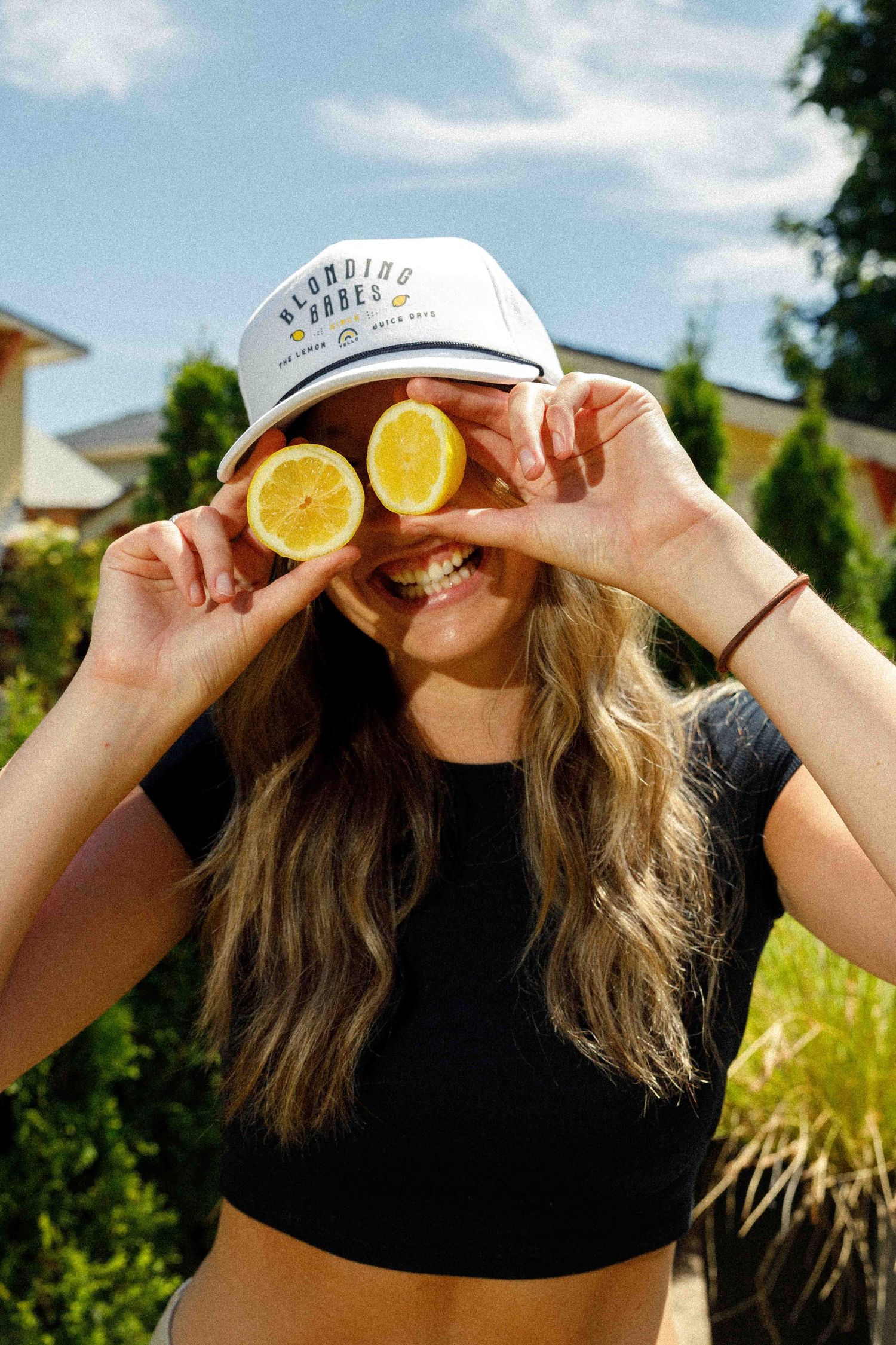 A creative collage of four photos showing hands holding citrus slices against sunny outdoor background.