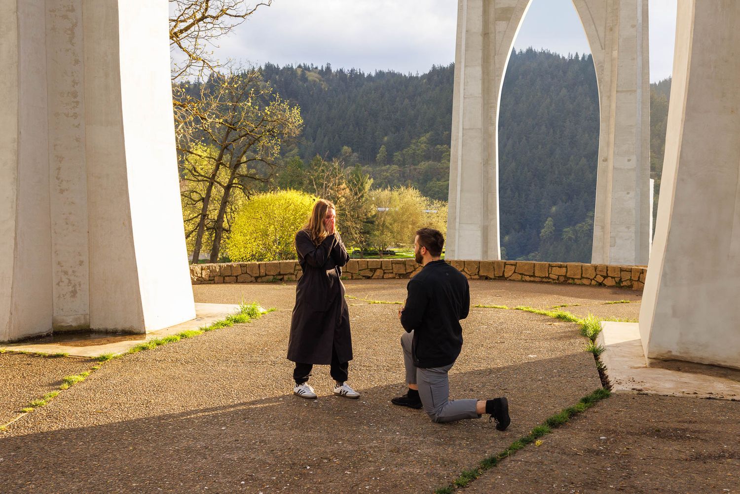 Concrete support pillars of a highway overpass or bridge structure frame views of a scenic mountainous landscape.