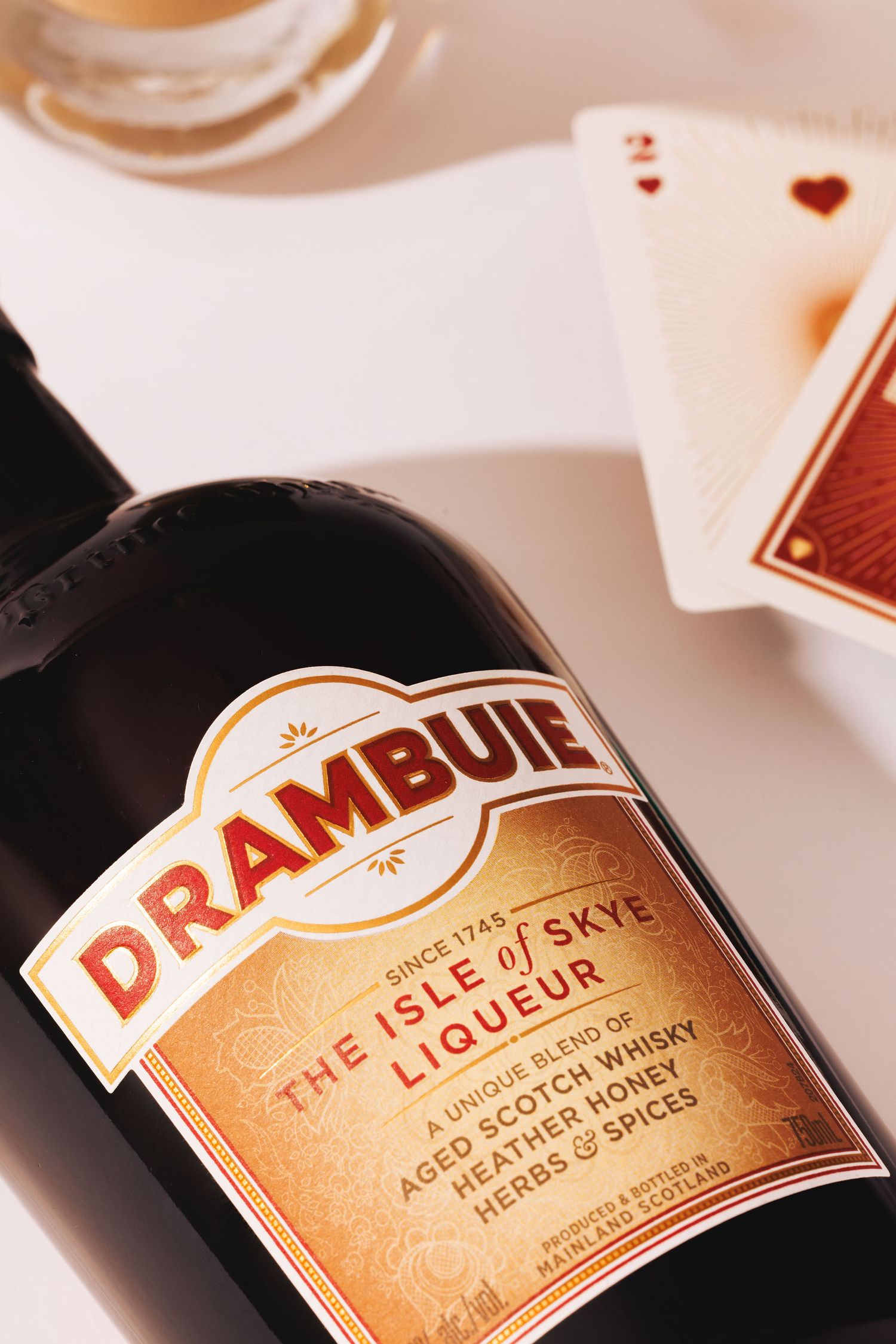 Close-up shot of a Drambuie whiskey bottle label showing golden text against dark glass background.