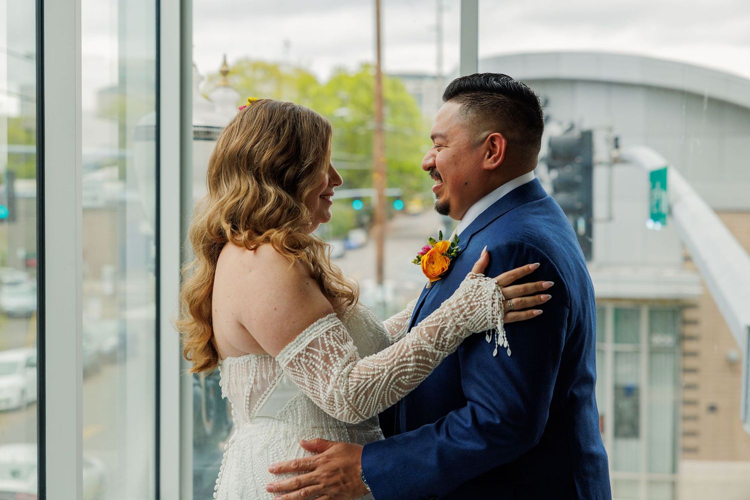 Couple embracing by glass windows in modern building interior.