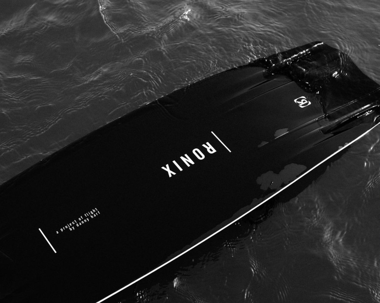 Black AMD Radeon graphics card floating on dark water surface with ripples and reflections.