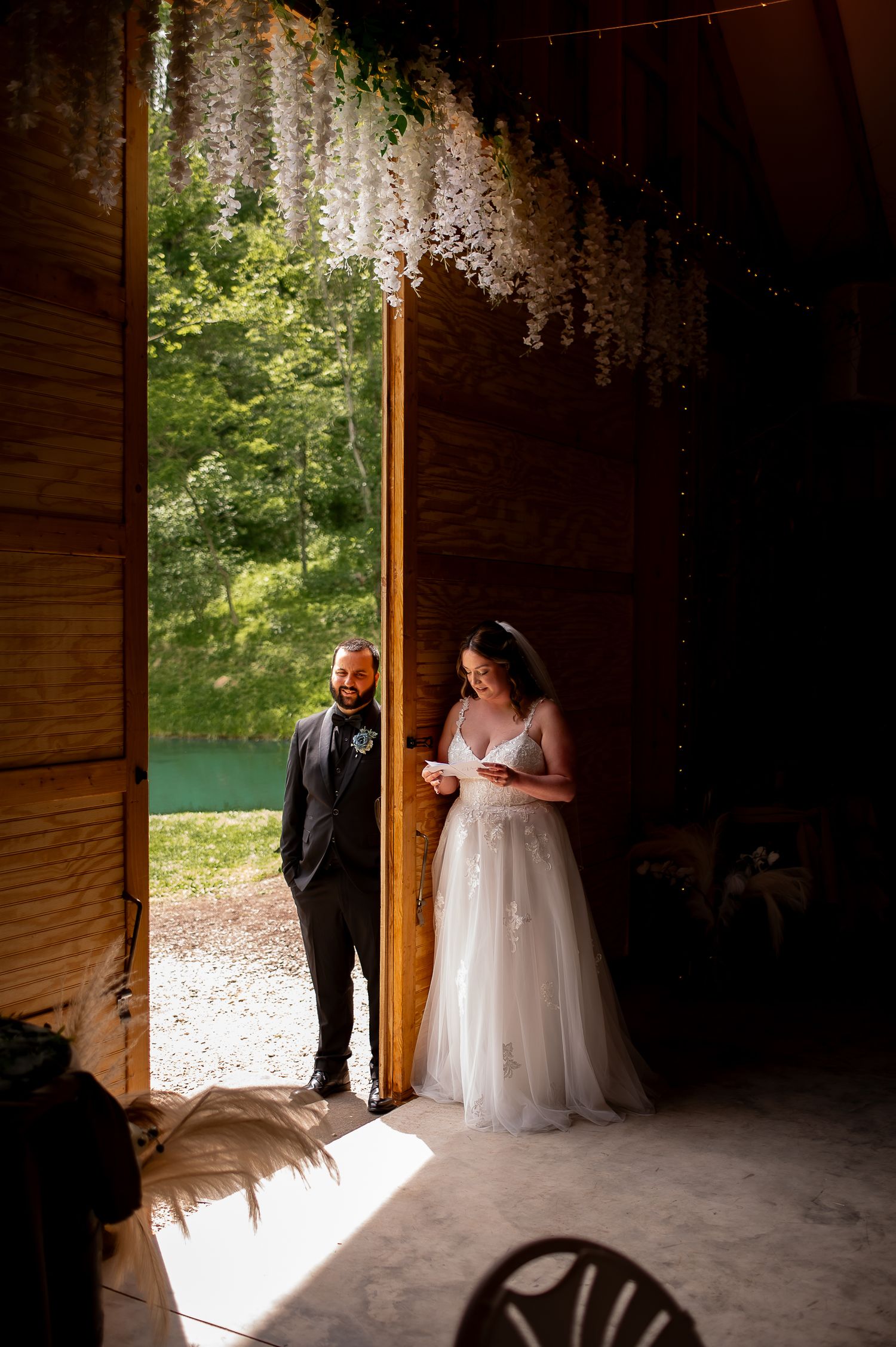 A couple shares a moment in a rustic barn doorway during their wedding.