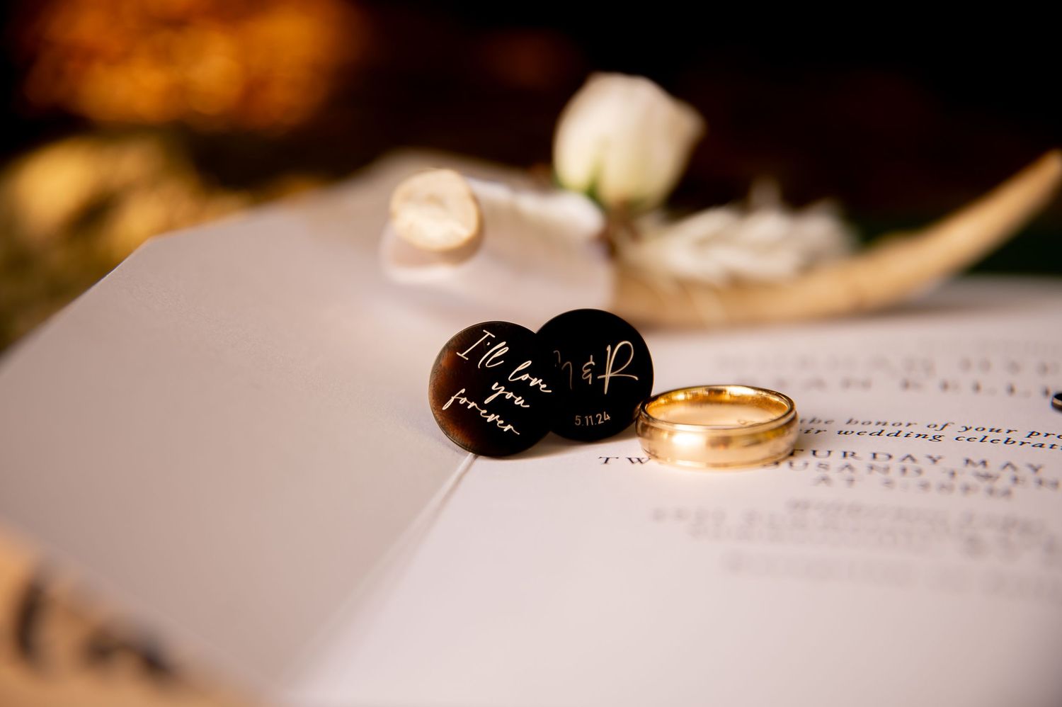 Wedding rings and cufflinks arranged artistically on a book page.