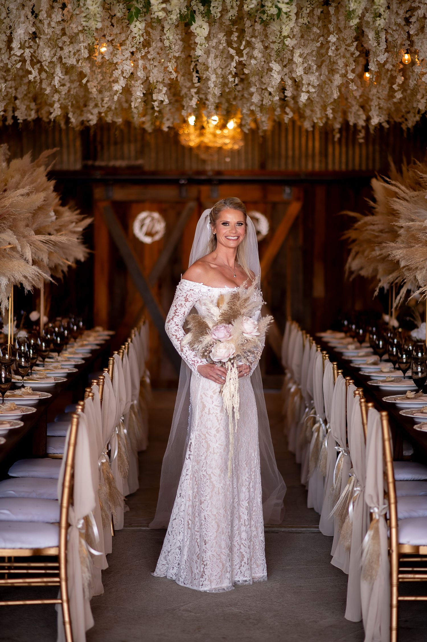 White lace wedding dress photographed in an elegant venue with floral decorations and ambient lighting.