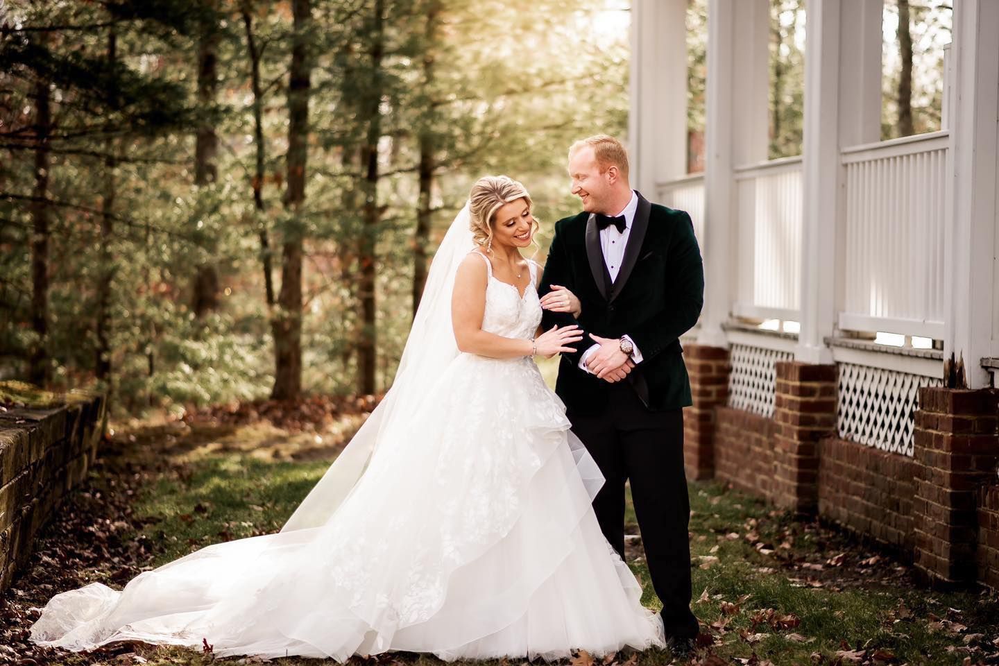 A romantic wedding scene with formal attire against a rustic brick building backdrop.