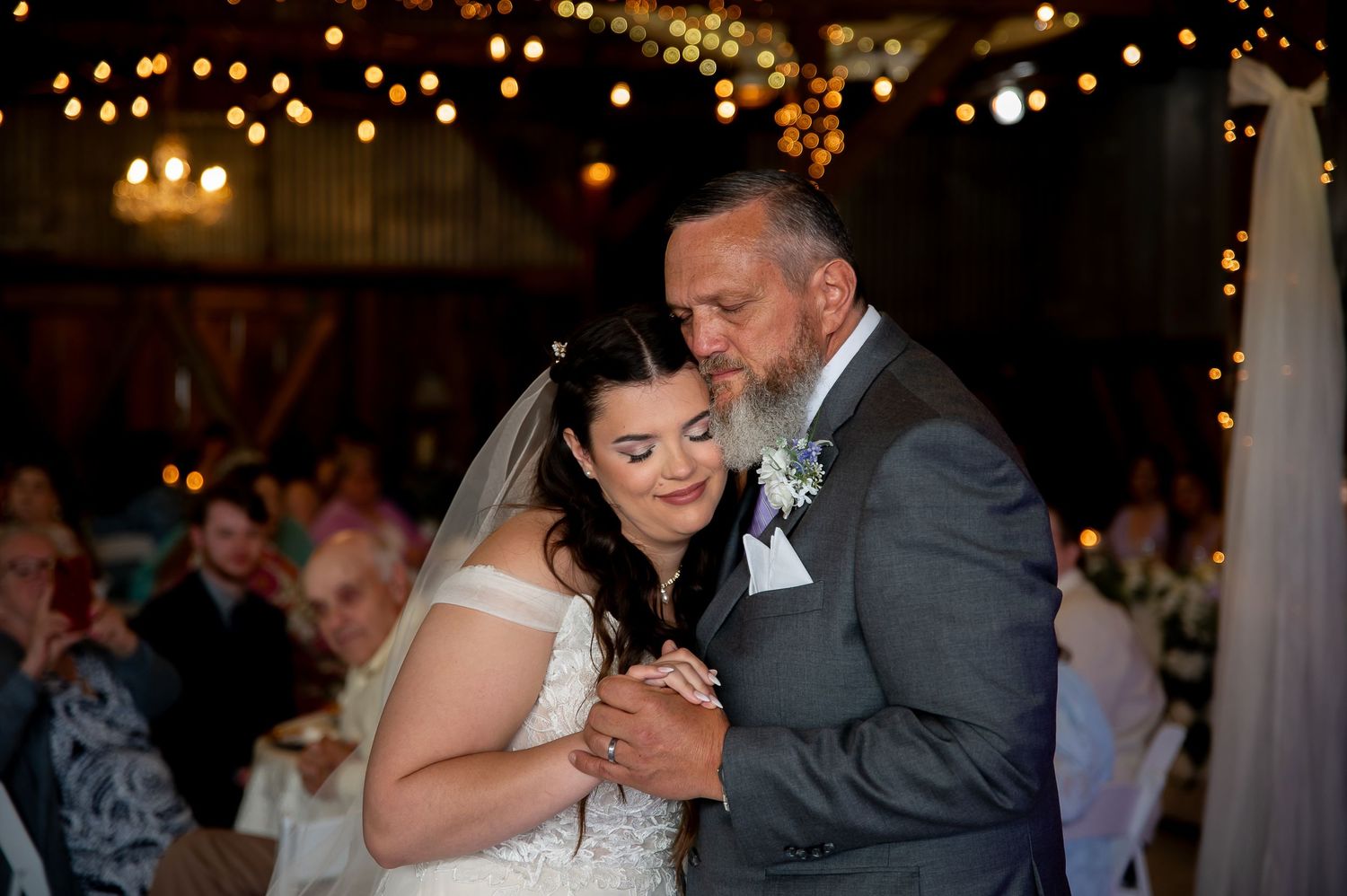 A romantic first dance under warm lighting at an evening wedding reception.