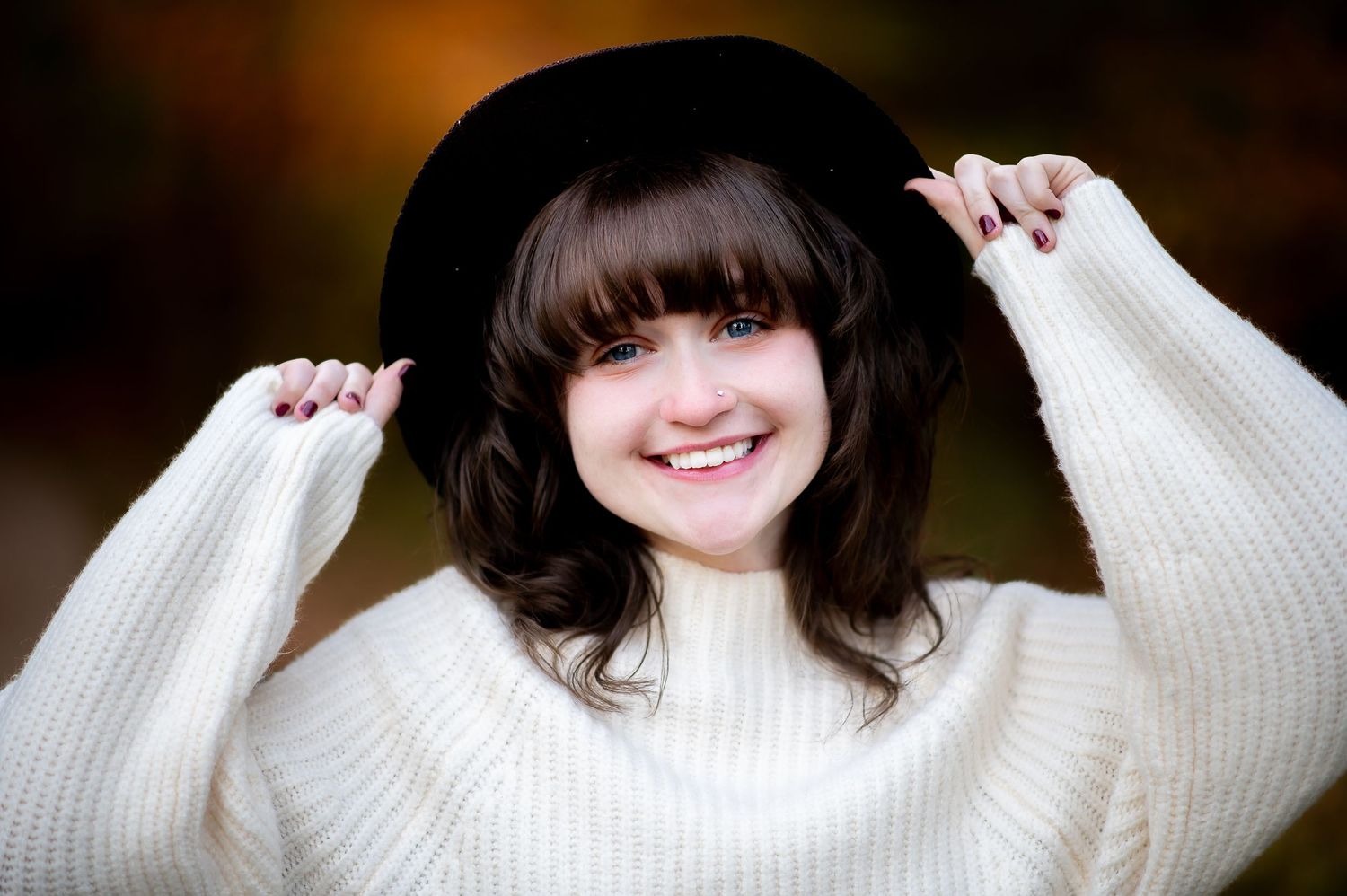 Close-up shot of white knit sweater against warm-toned background.