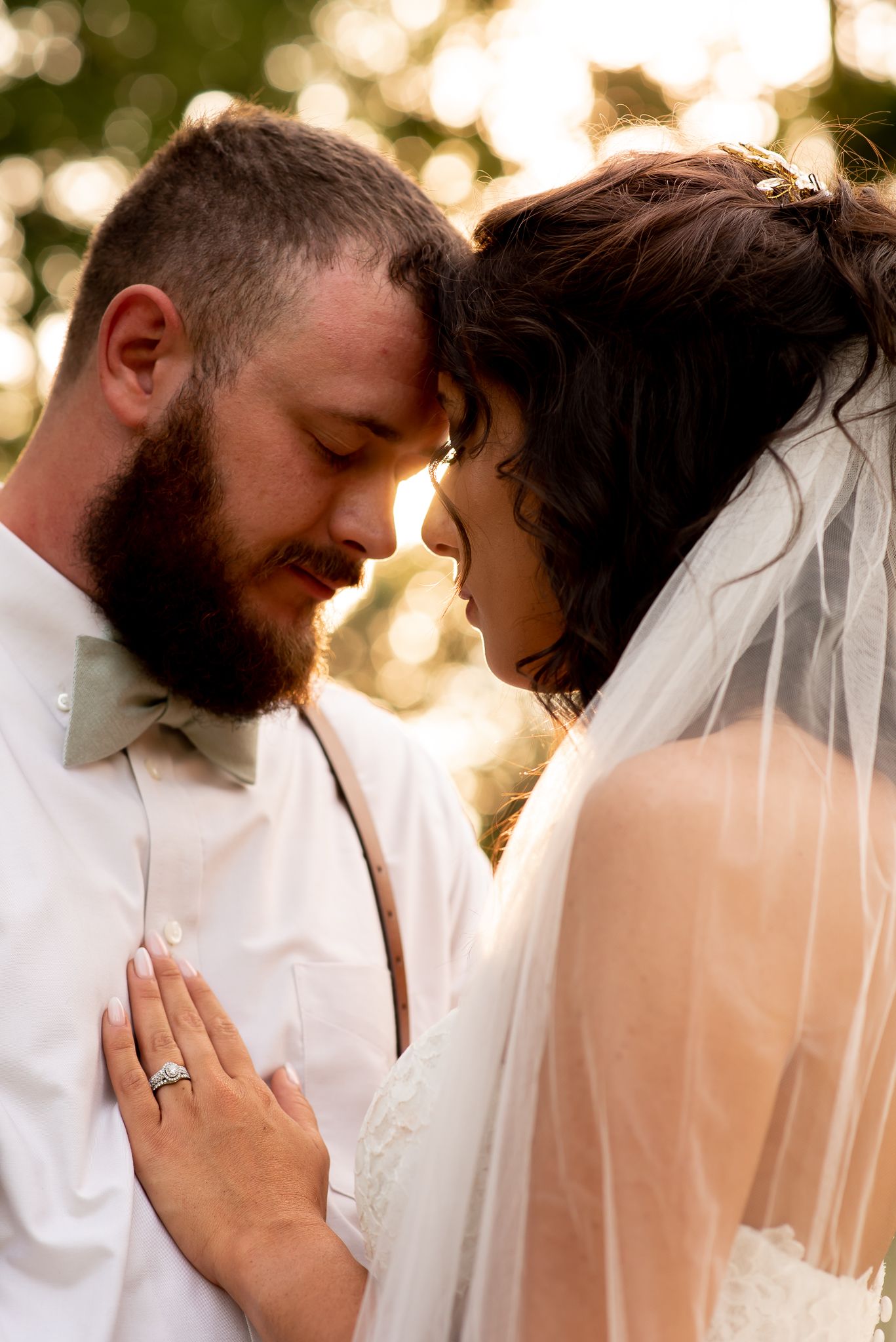 A tender moment between newlyweds captured in warm golden sunlight.