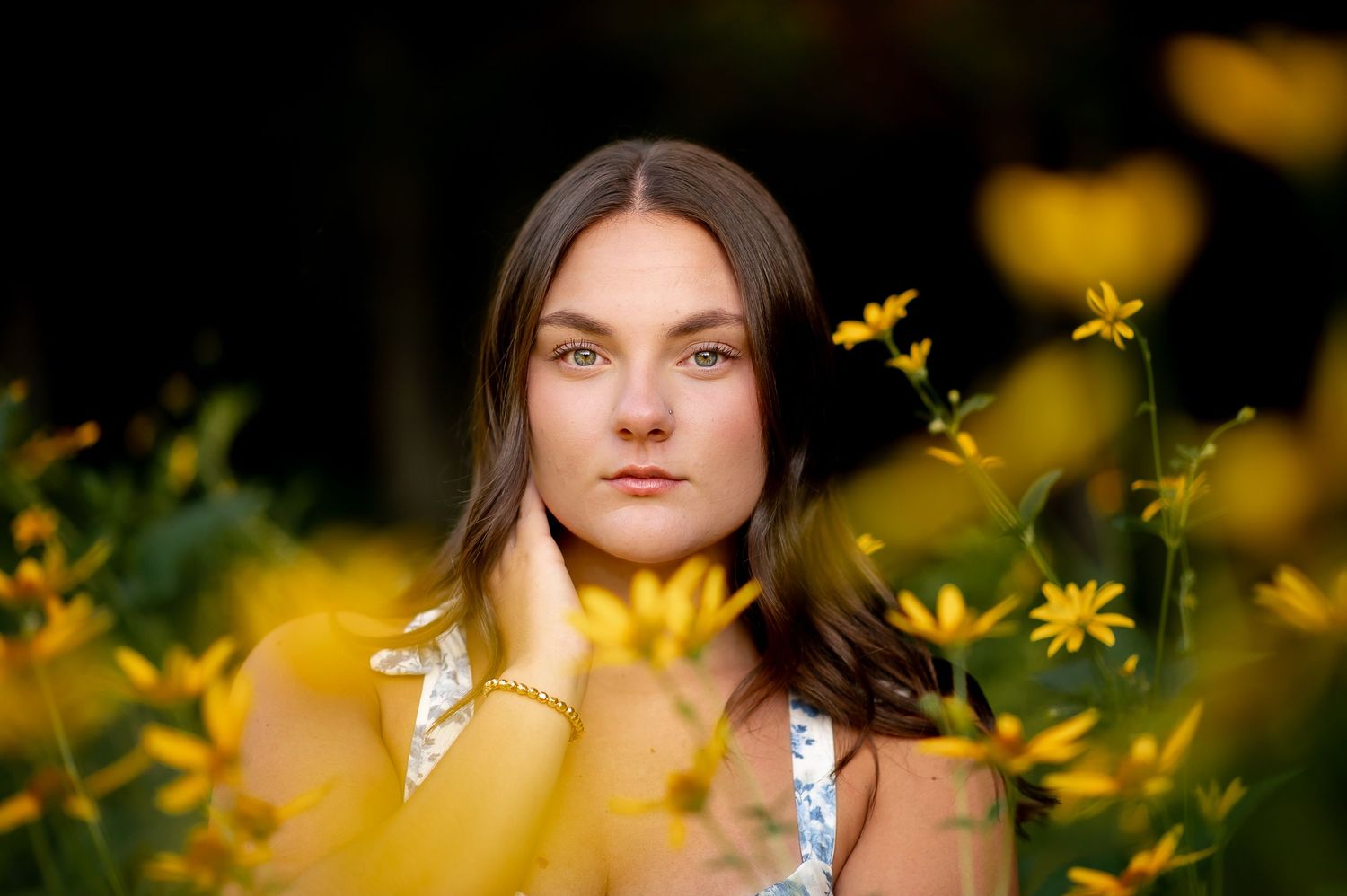 Artistic portrait in a dreamy yellow wildflower field with soft sunlight creating a warm, ethereal atmosphere.